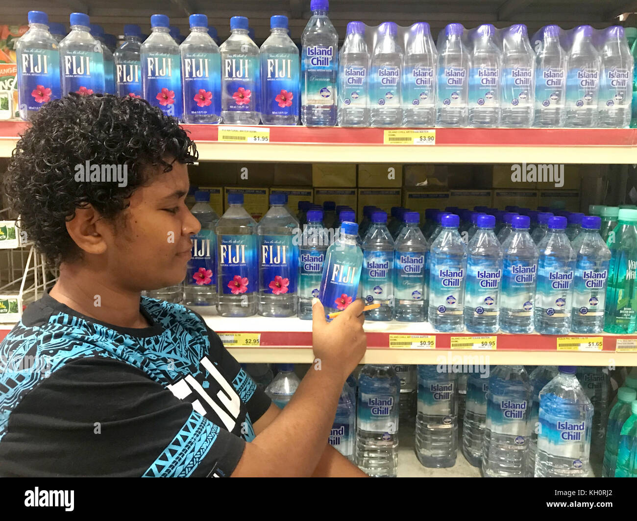 A woman examines a bottle of Fiji water in a supermarket in Nadi on the Fiji Islands, 20 October 2017. One liter of Fiji water sells on the Fiji Islands at a low price in comparison to the same water sold overseas at five Euros and more. Photo: Christoph Sator/dpa Stock Photo