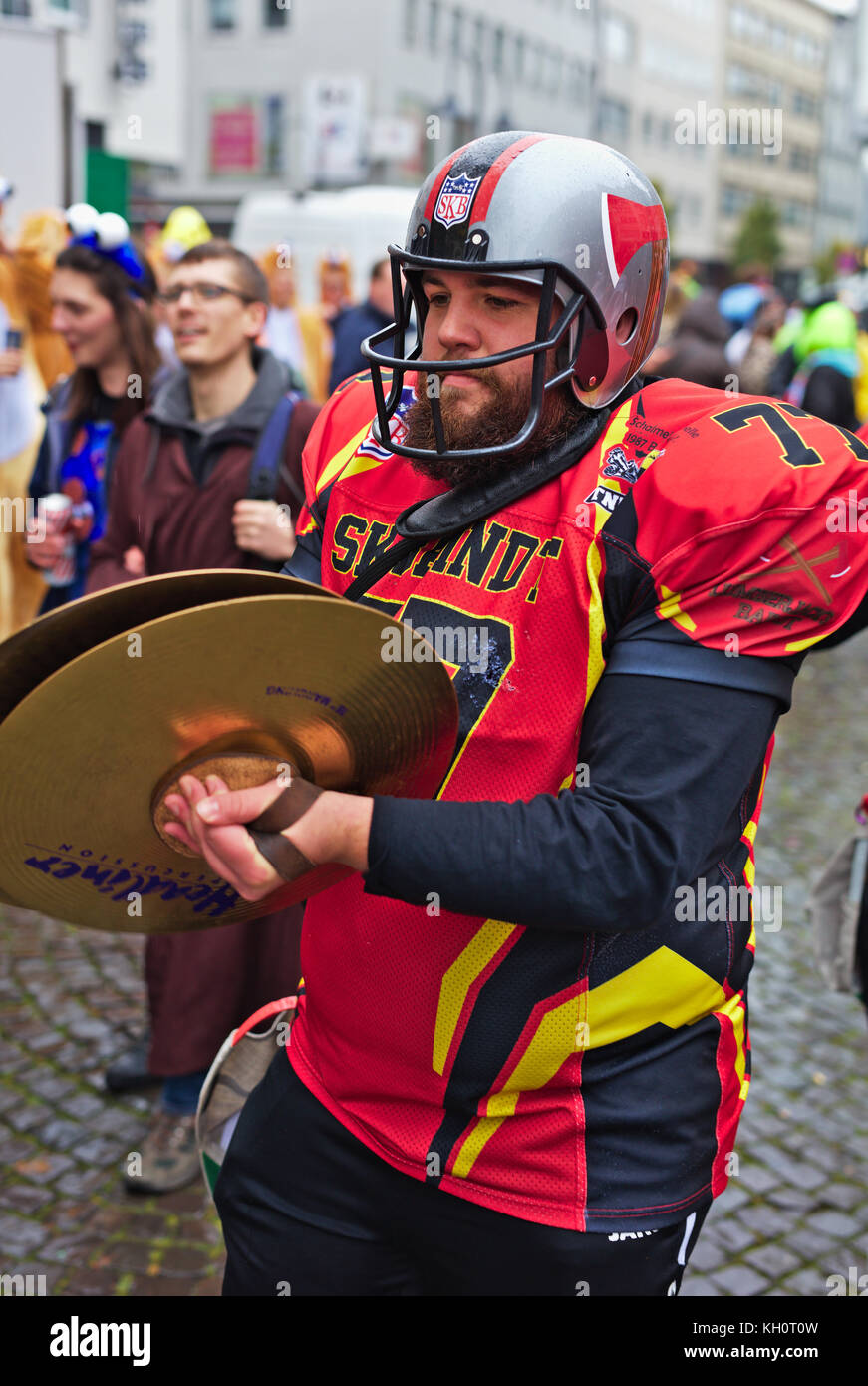 Cologne, Germany, 11 Nov, 2017, Cologne traditionally opens the carnival season Nov. 11th every year. People dressed up and went outside despite the rainy weather. Picture shows a musician dressed up in american fooball dress, Detlef Herklotz / Alamy Live News Stock Photo