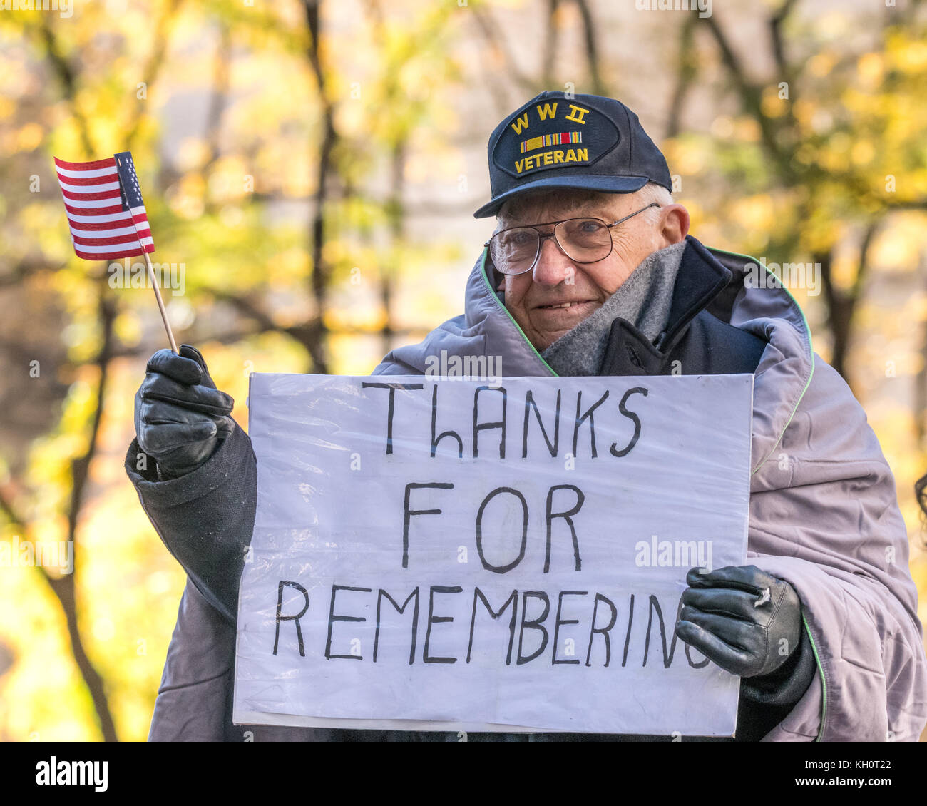 New York, USA, 11 Nov 2017.  A World War II veteran waves a US flag as he holds a sign reading 'Thanks for Remembering' from atop a float as he participates in the 2017 Veterans Day parade. Photo by Enrique Shore/Alamy Live News Stock Photo