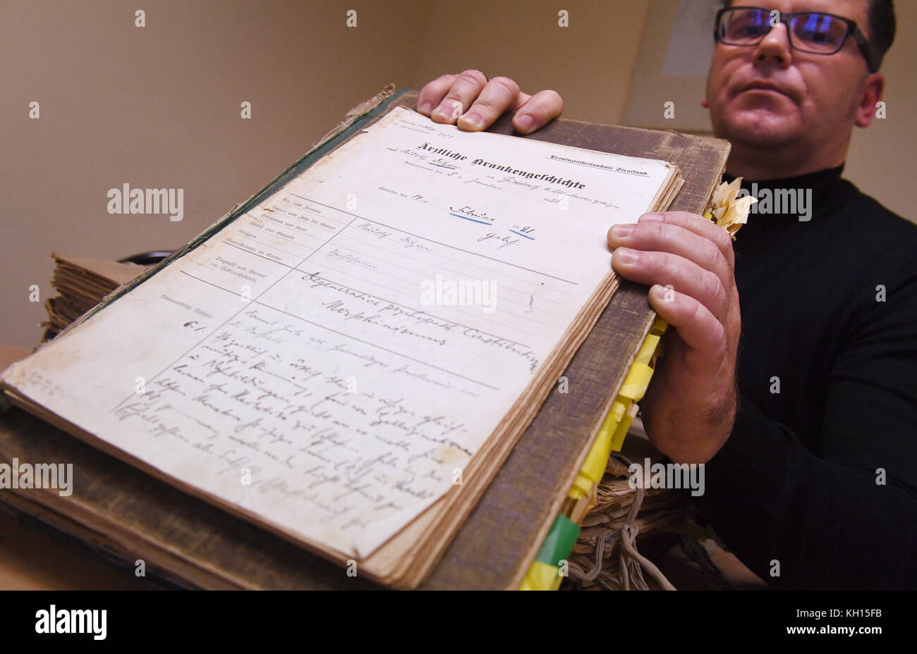 Stralsund, Germany. 08th Nov, 2017. Dr. Jan Armbruster, leading senior physician of the Stralsund forensic psychiatry, holding up the Falla file from 1921 in Stralsund, Germany, 08 November 2017. The renown author Rudolf Ditzen, whose pseudonym is Hans Fallada, is among about 1000 files of patients between 1912 and 1939 that are being handed over to the national archive in Mecklenburg-Western Pomerania on 17 November 2017. Credit: Stefan Sauer/dpa/Alamy Live News Stock Photo