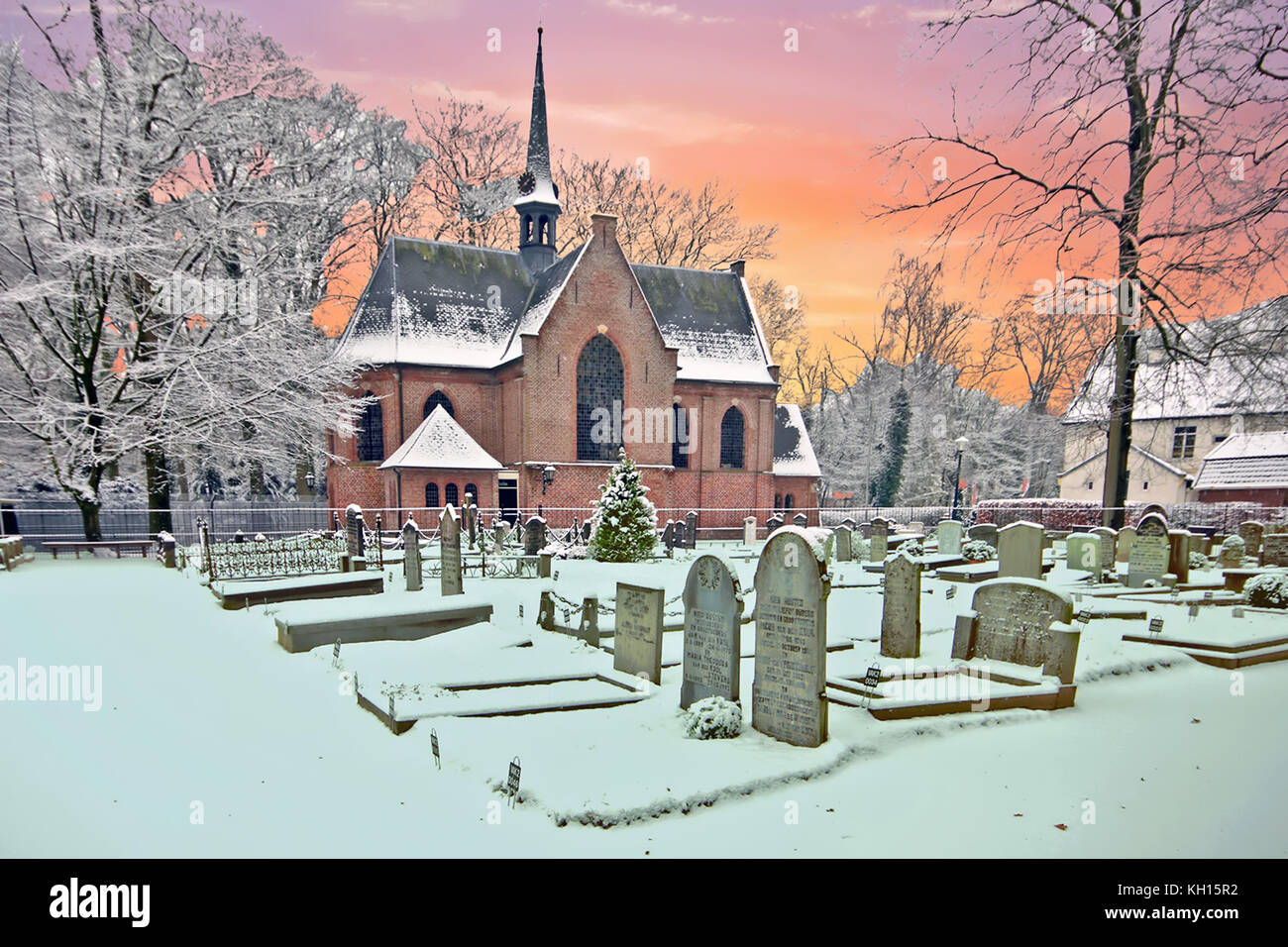 Snowy traditional medieval church in Lage Vuursche the Netherlands at sunset Stock Photo