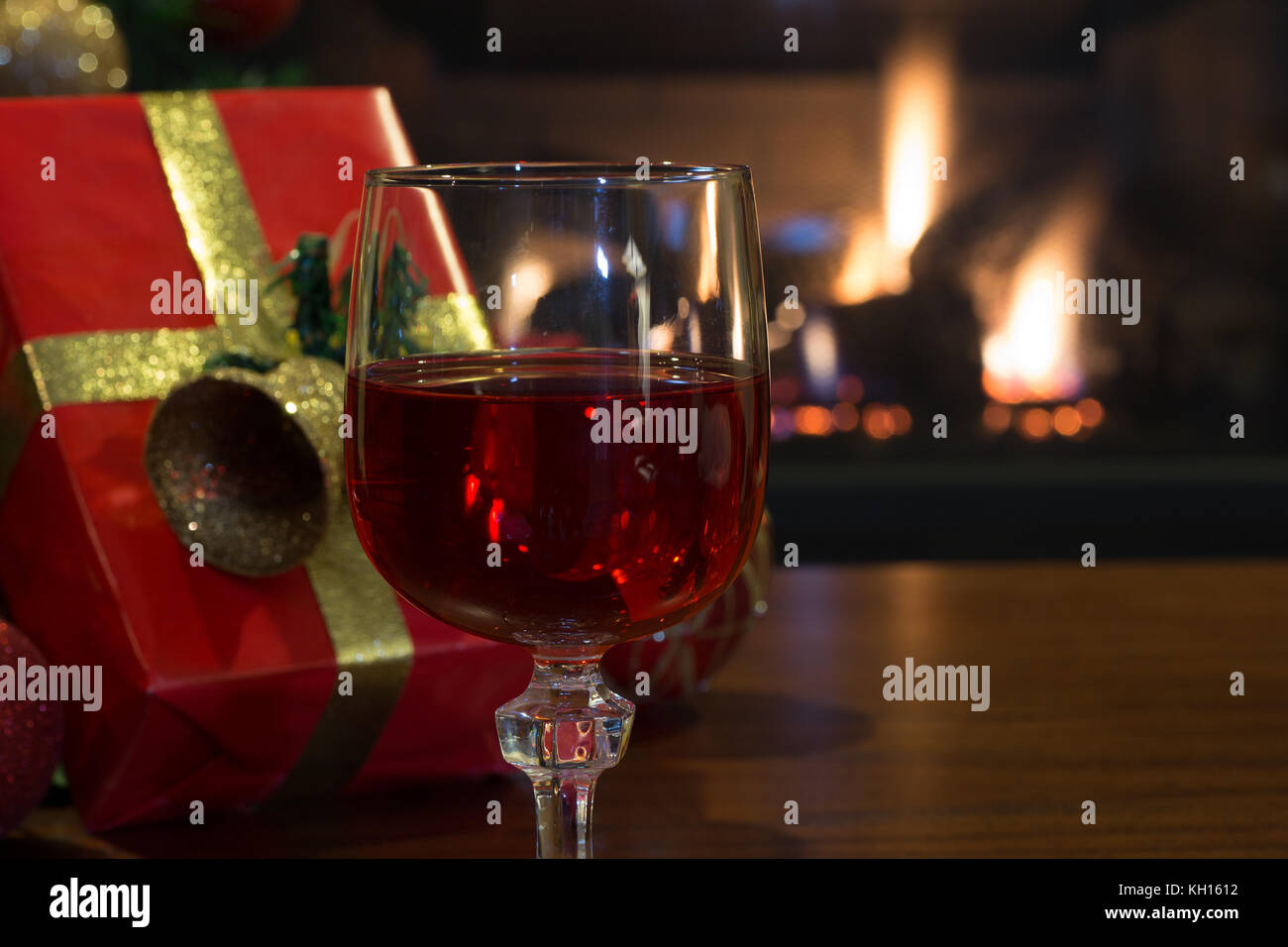 Mulled wine glasses on table in front of burning fireplace. Stock