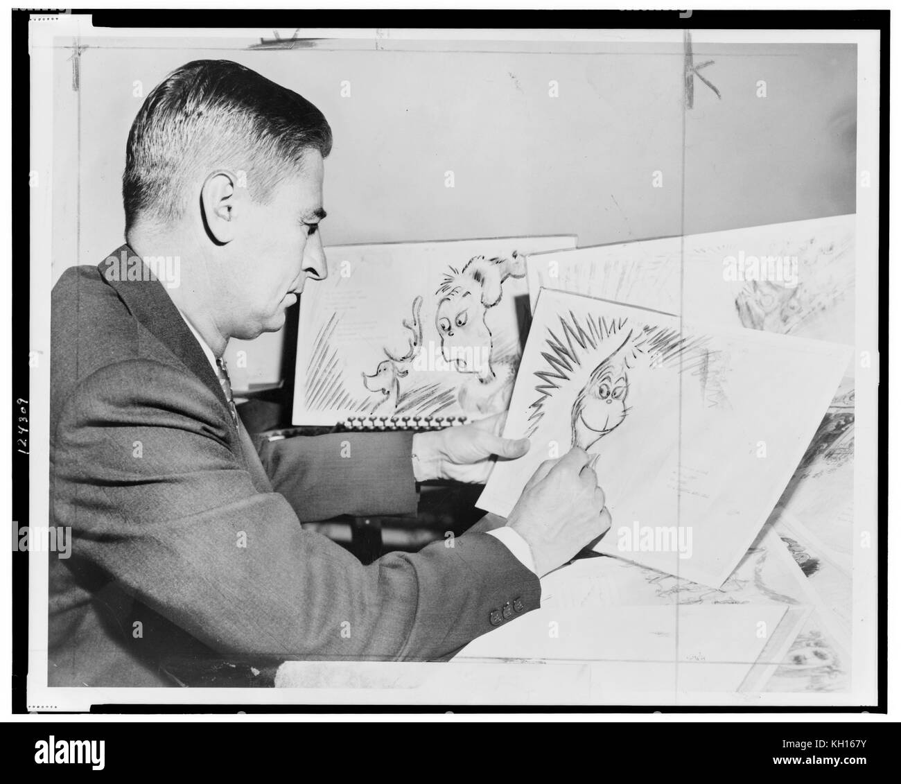 Dr. Seuss (Ted Geisel) at work on a drawing of a grinch, the hero of his forthcoming book, 'How the Grinch Stole Christmas.' Photo by Al Ravenna. New York, NY 1957. Stock Photo