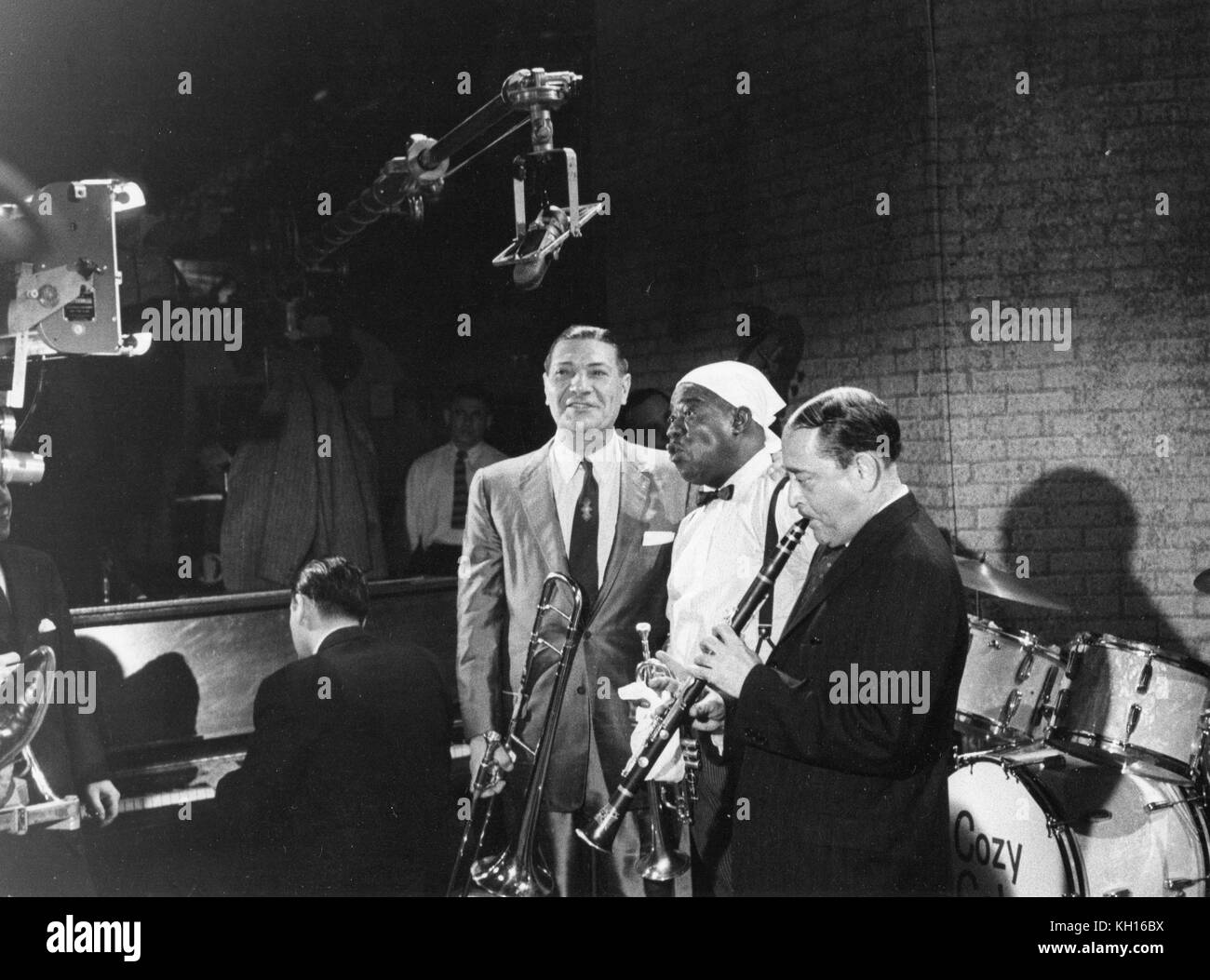 Jack Teagarden (left, directly under microphone boom), pioneer American jazz trombonist, is shown rehearsing for a television show with equally famous trumpeter Louis Armstrong (center) and clarinetist Tony Parenti (to the right of Armstrong), New York, NY, 1958. Stock Photo