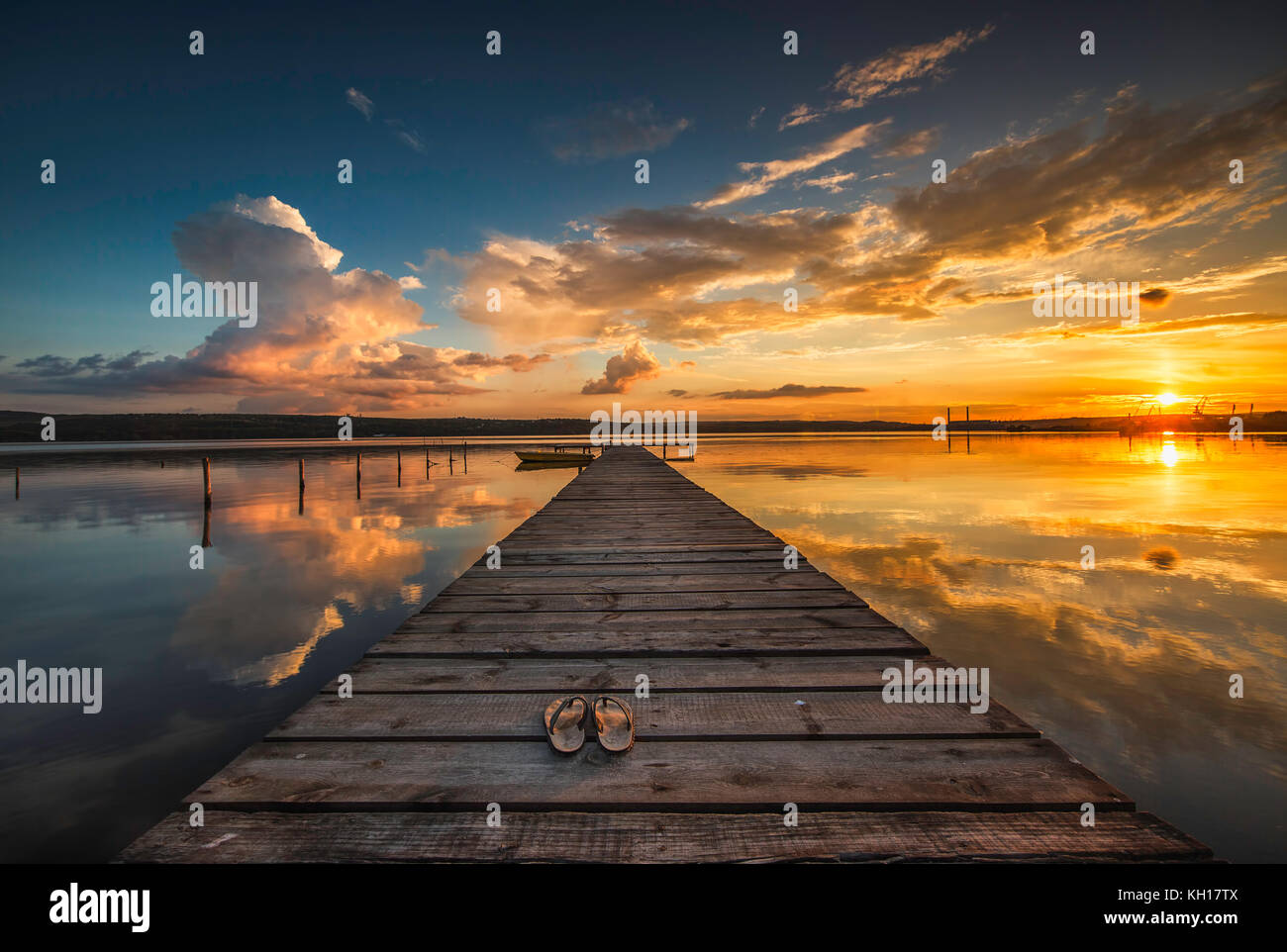 Small Dock and Boat at the lake, sunset shot Stock Photo - Alamy