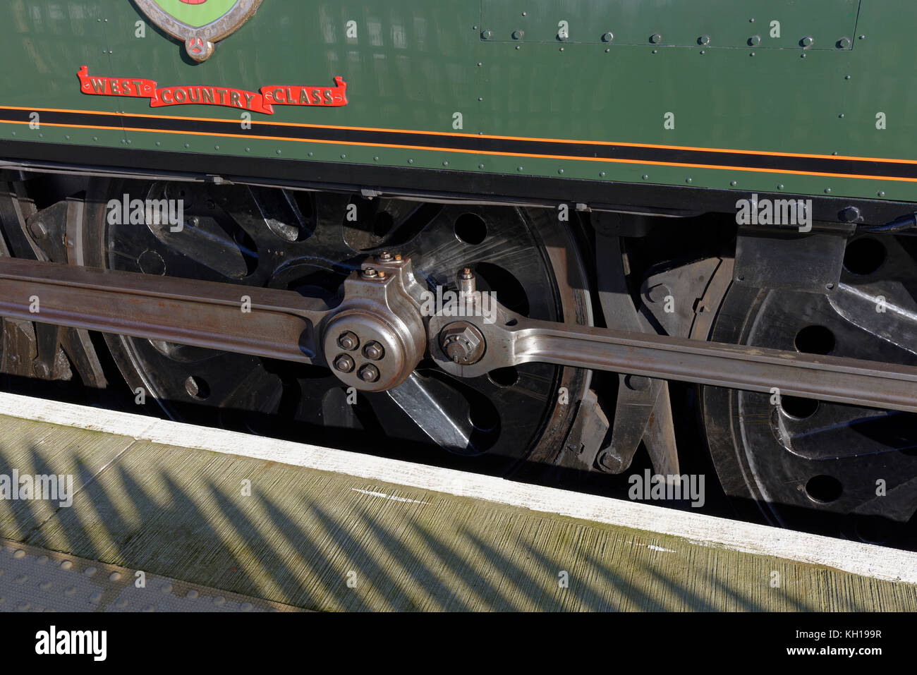 Steam running gear close up at edge of railway platform on