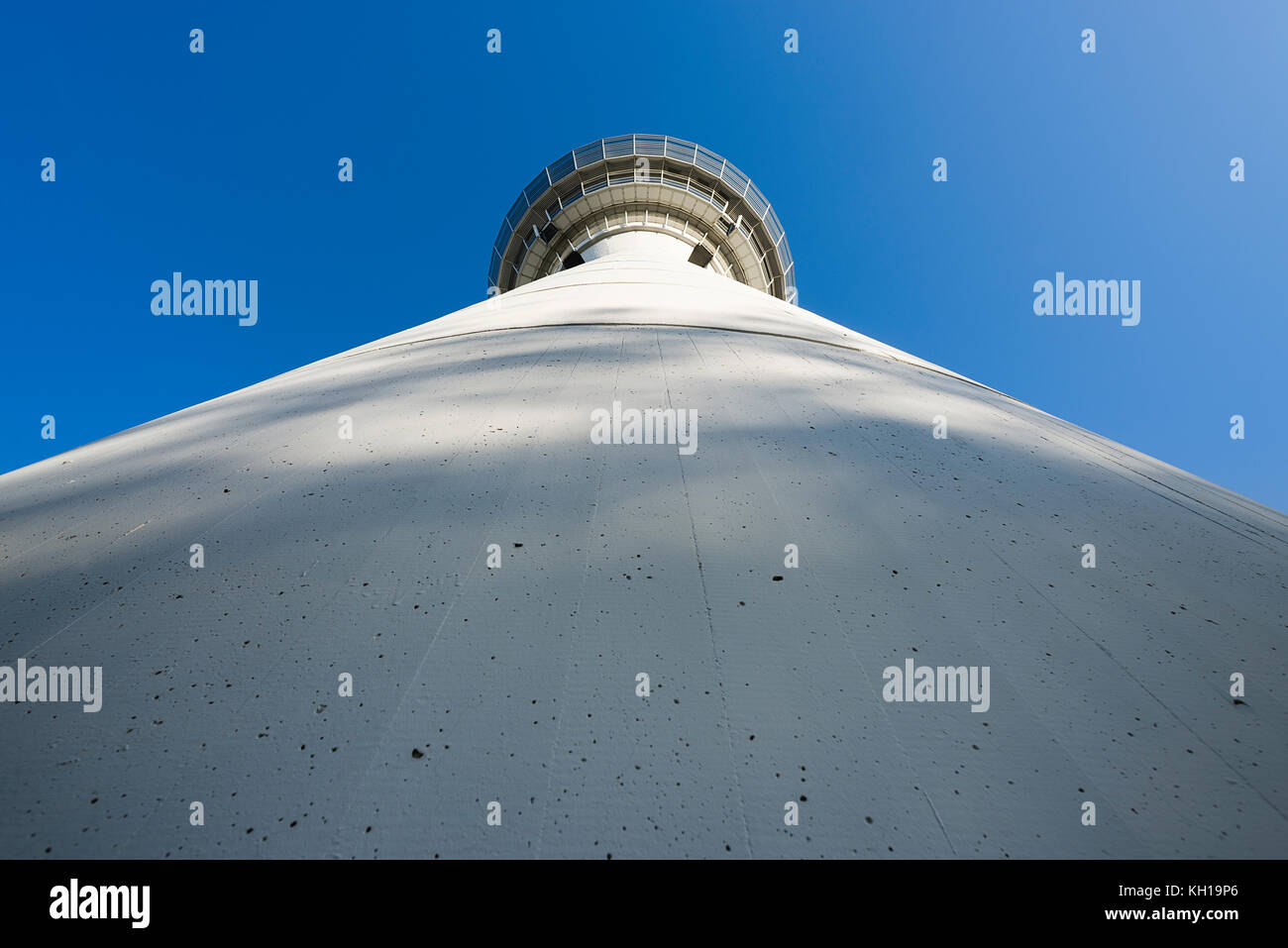 Cilyndrical facade of white air traffic control tower of Munich airport MUC in morning sun in front of blue cloudless sky, Bavaria, Germany Stock Photo