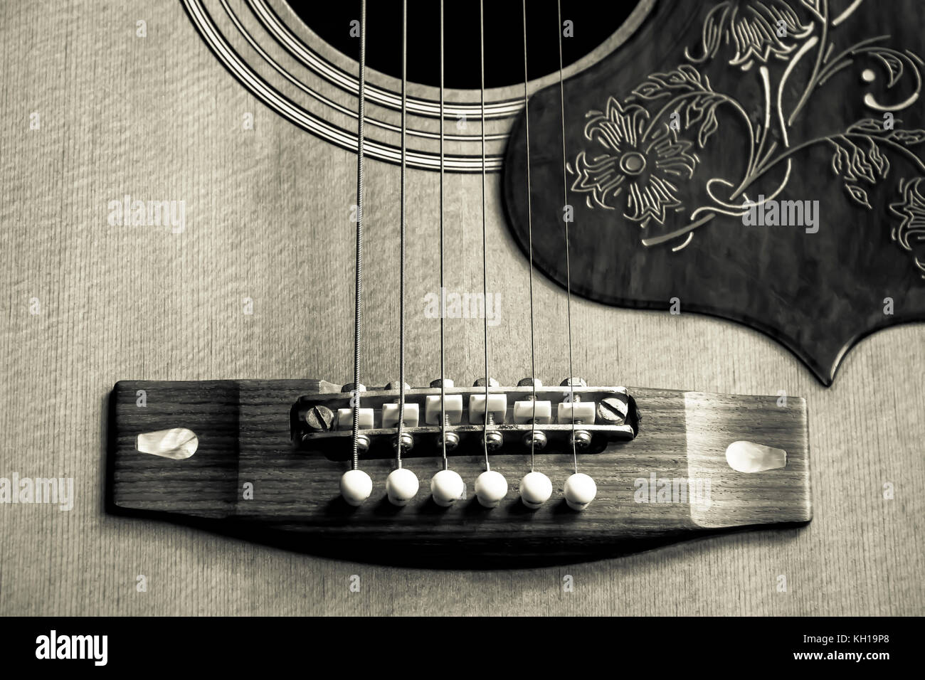 Sepia-toned close-up image of the bridge and sound hole of a 1970s Yamaha FG-300 acoustic steel-strung guitar Stock Photo