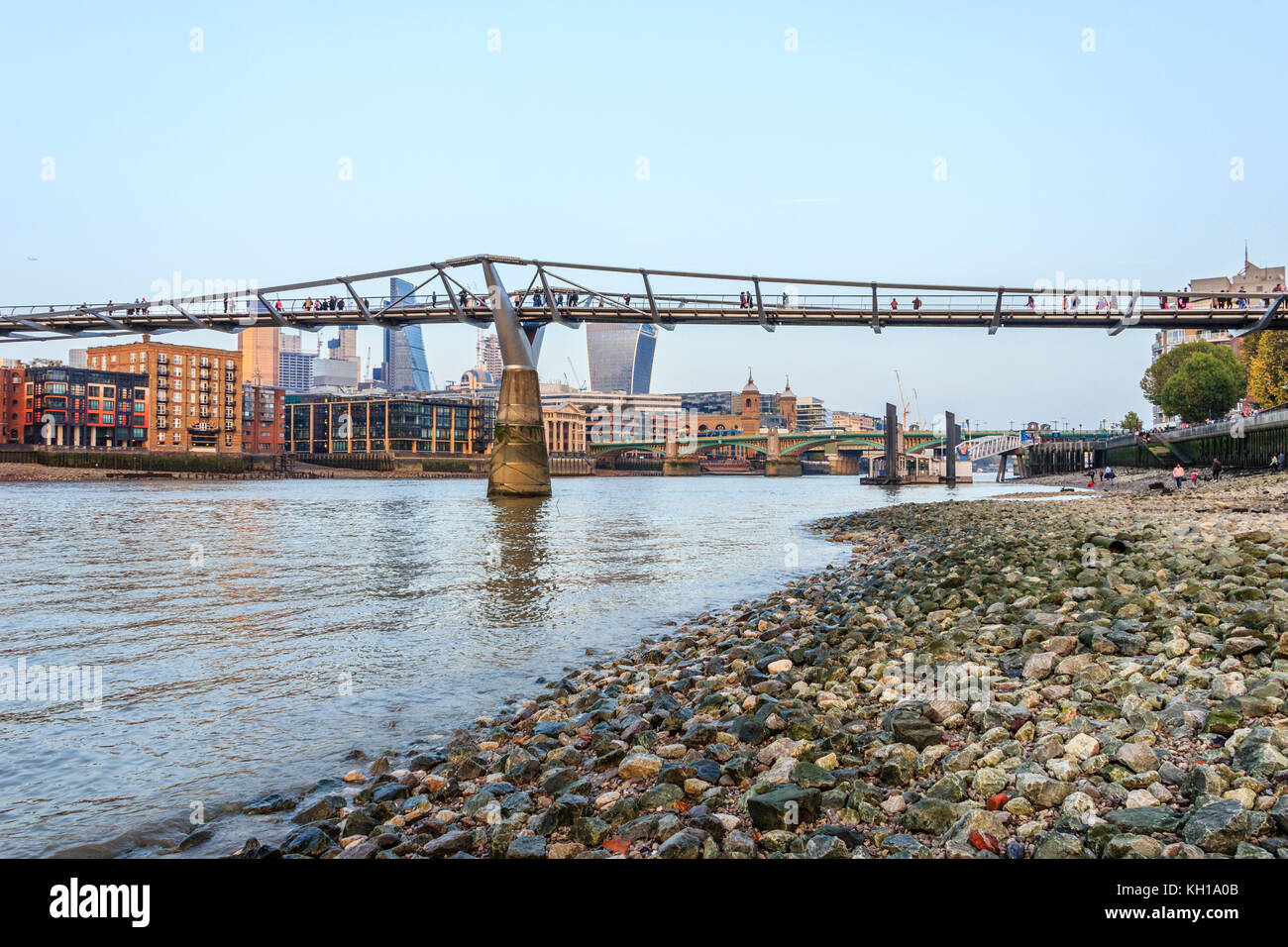The Millennium Bridge, London, UK, seen from the Thames foreshore at Bankside, at low tide on an autumn evening Stock Photo