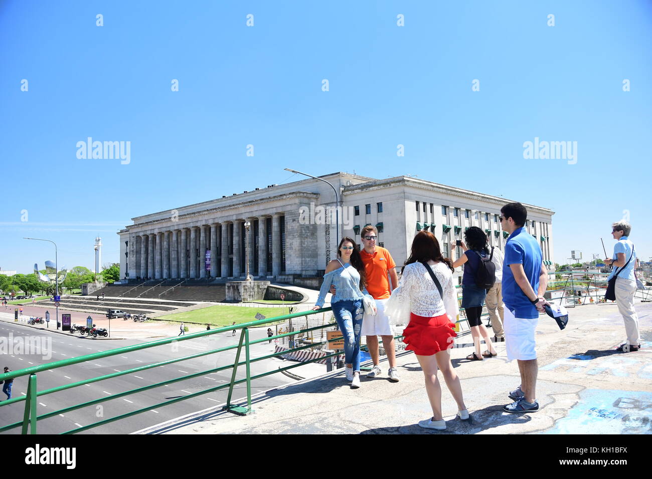 Tourists pose for picture while standing on a bridge in front of University of Buenos Aires Law School building. Stock Photo