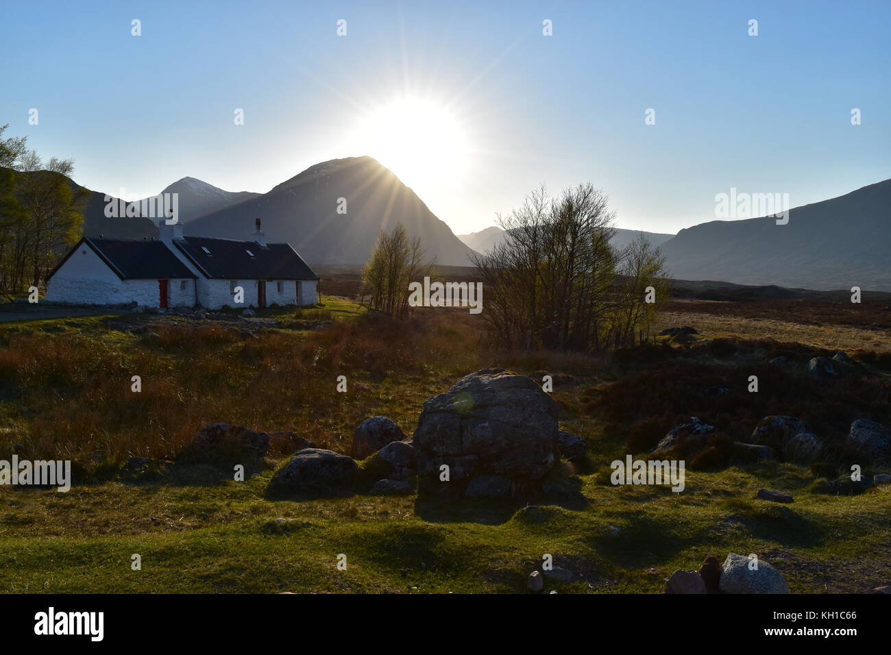 Black Rock Cottage on a sunny spring day as the sun goes down, Glencoe, Scotland. Stock Photo