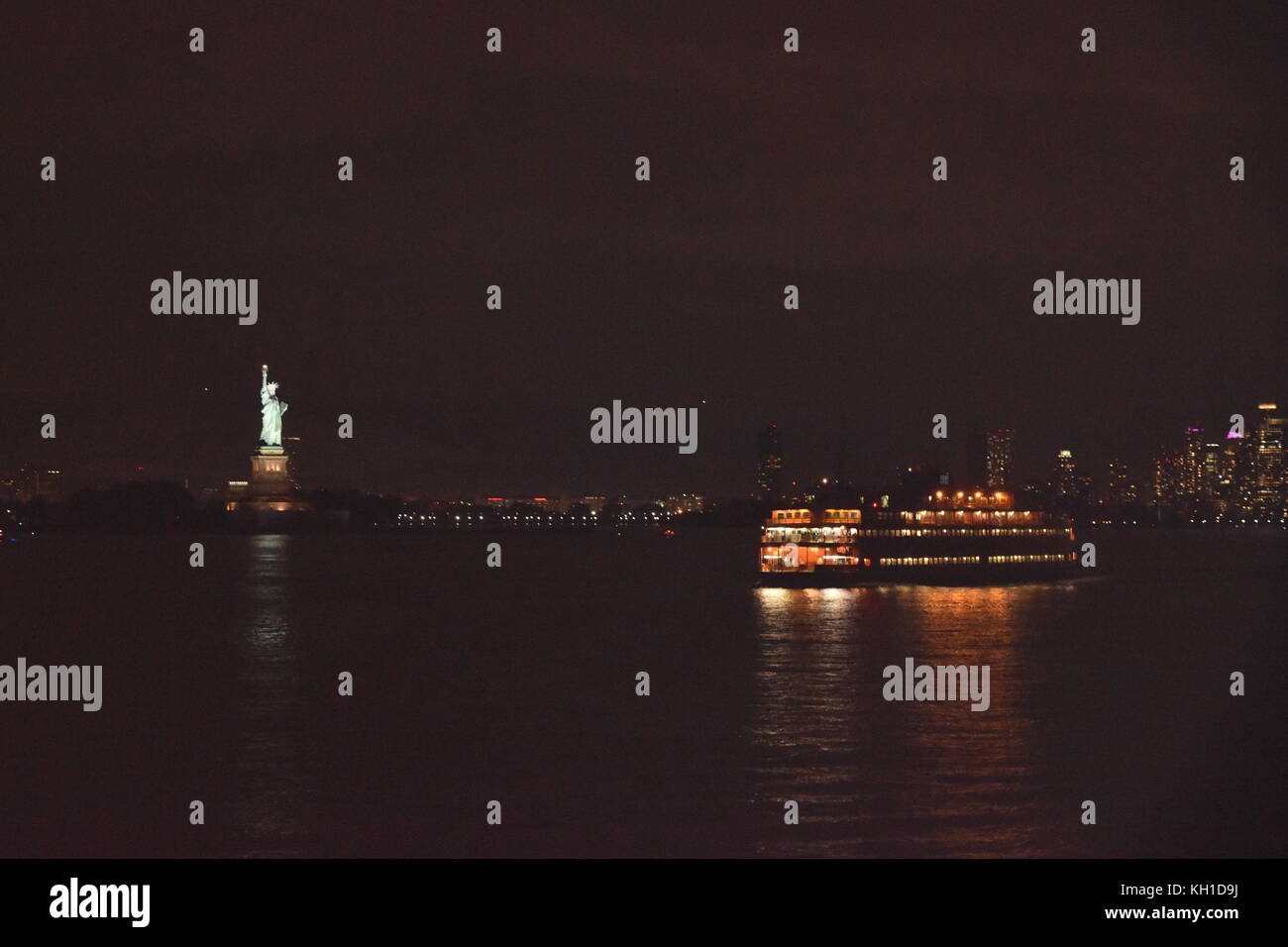 Statue of Liberty and Staten Island Ferry at night, New York City Stock Photo