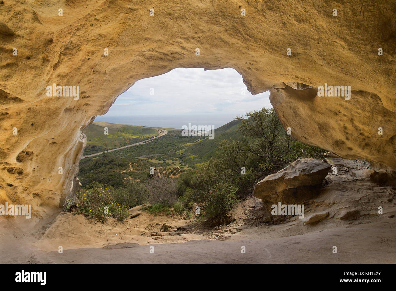 Cave looking out to road and ocean Stock Photo