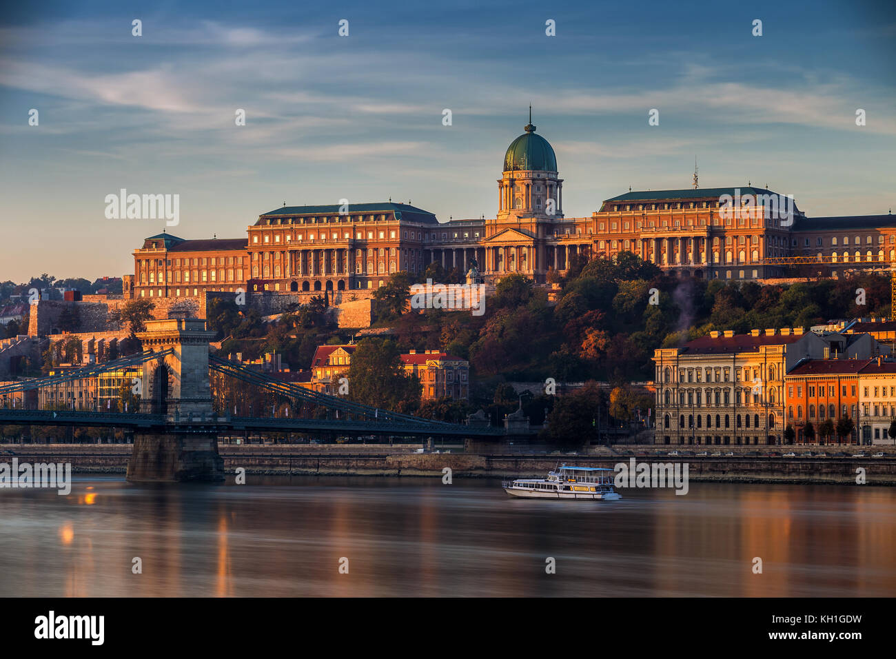 Budapest, Hungary - Beautiful golden sunrise at the Buda side with Buda Castle Royal Palace, Szechenyi Chain Bridge and sightseeing boat on River Danu Stock Photo