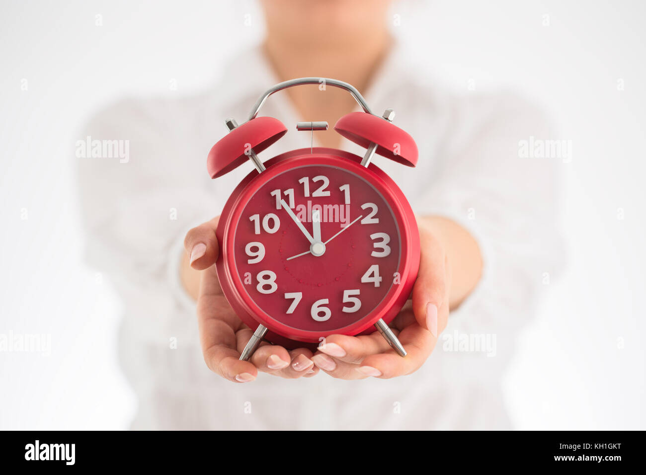 Counting hours expecting child birth. Motherhood concept. Pregnant woman holding alarm clock, studio shot. Stock Photo