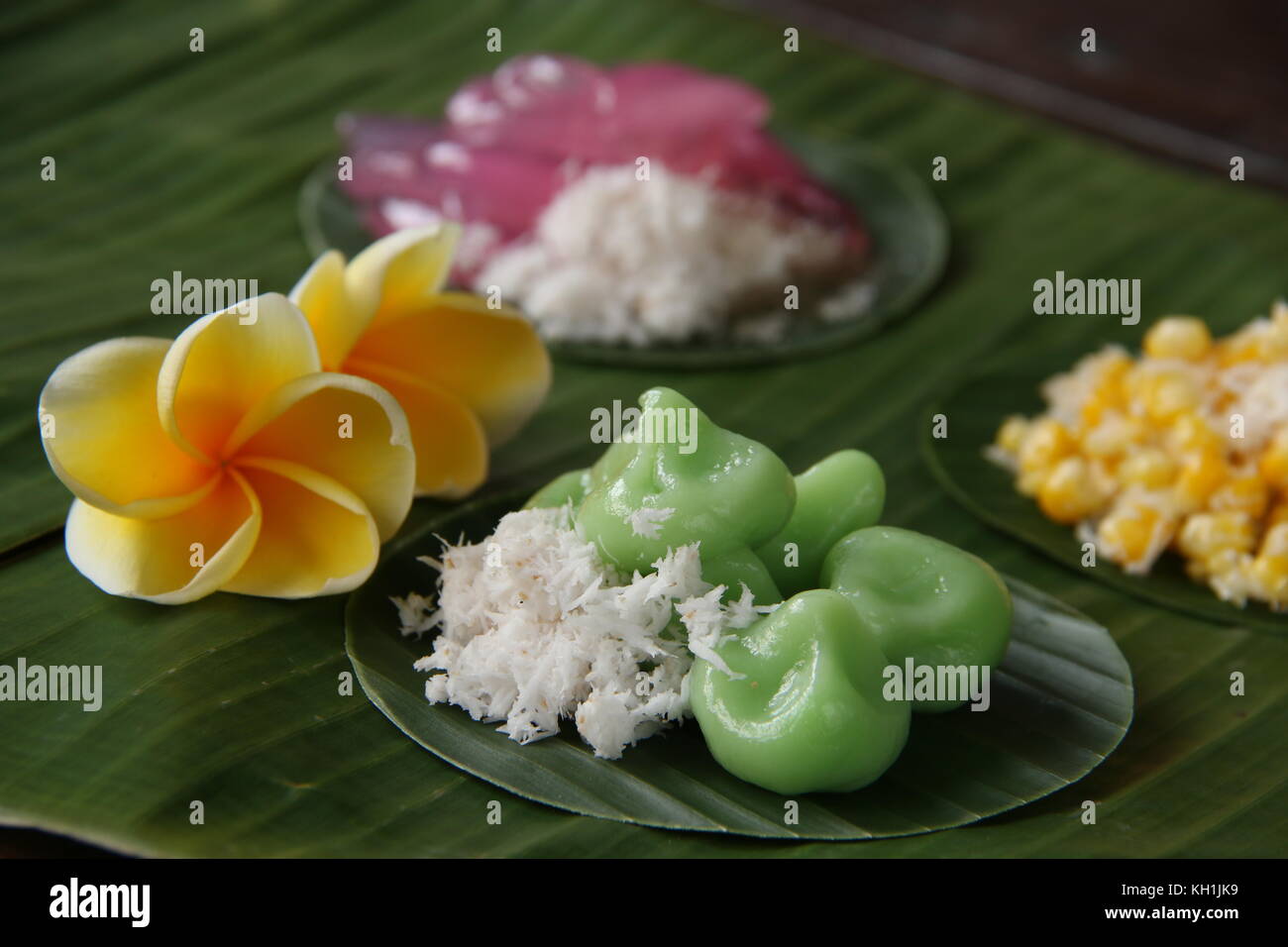 Jaja Klepon, traditional Balinese snack of pandanus glutinous rice balls filled with palm sugar, served with grated coconut Stock Photo
