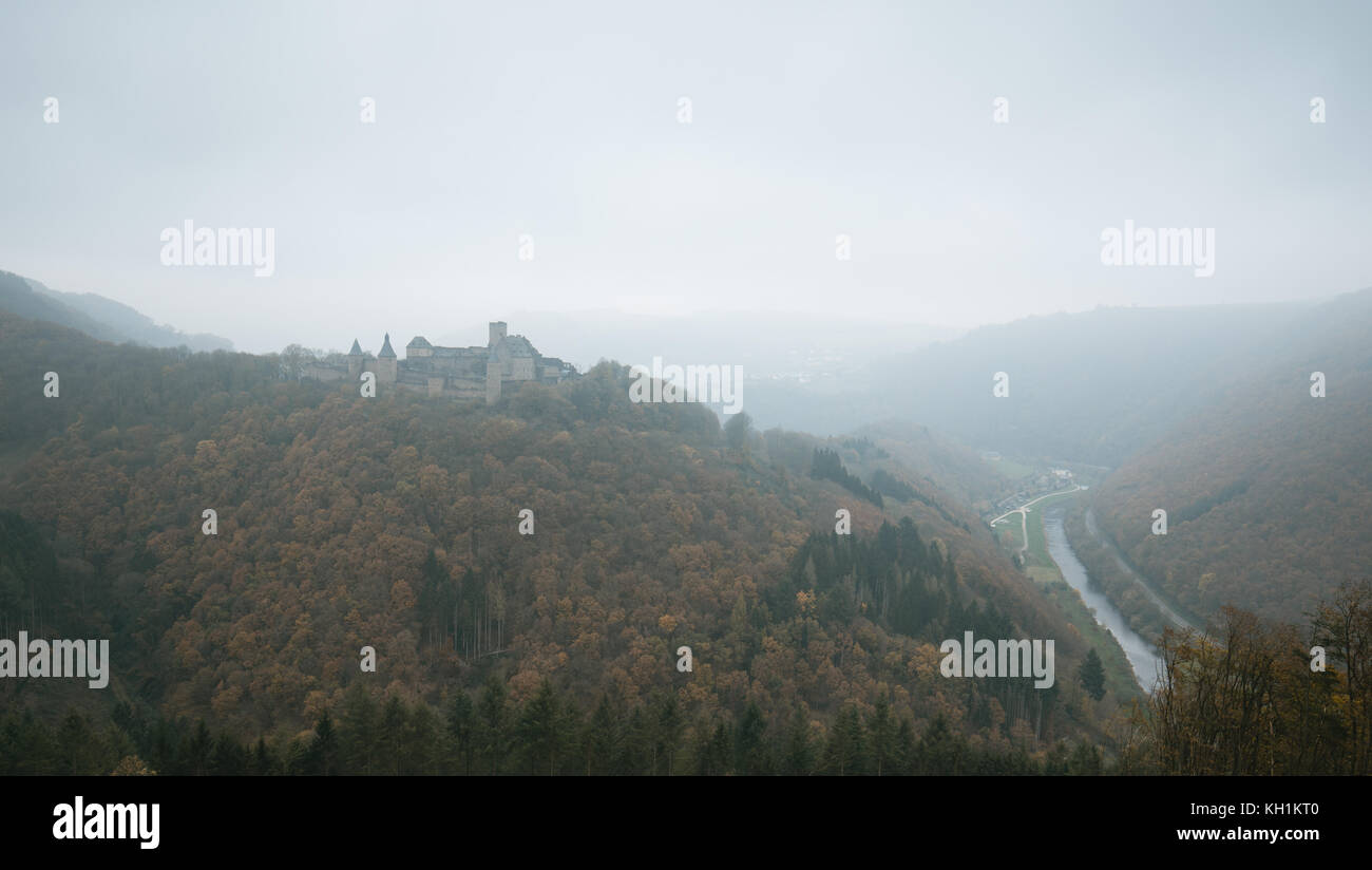 Bourscheid castle in the fog. Old fortress on a hill in Luxembourg. Autumn colors. Stock Photo