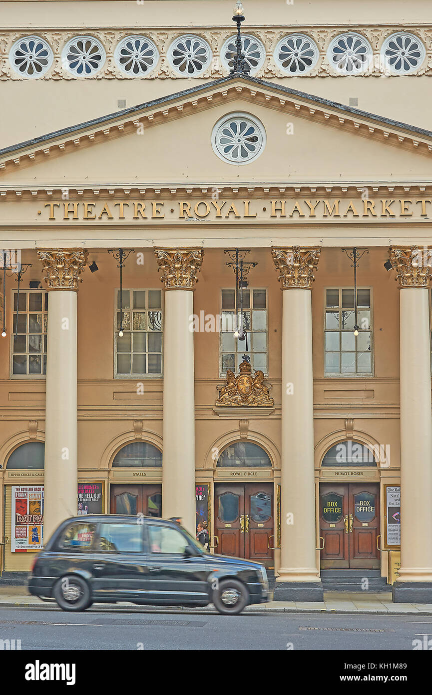 An iconic black London taxi passes the front of the Theatre Royal, Haymarket in London's theatreland Stock Photo