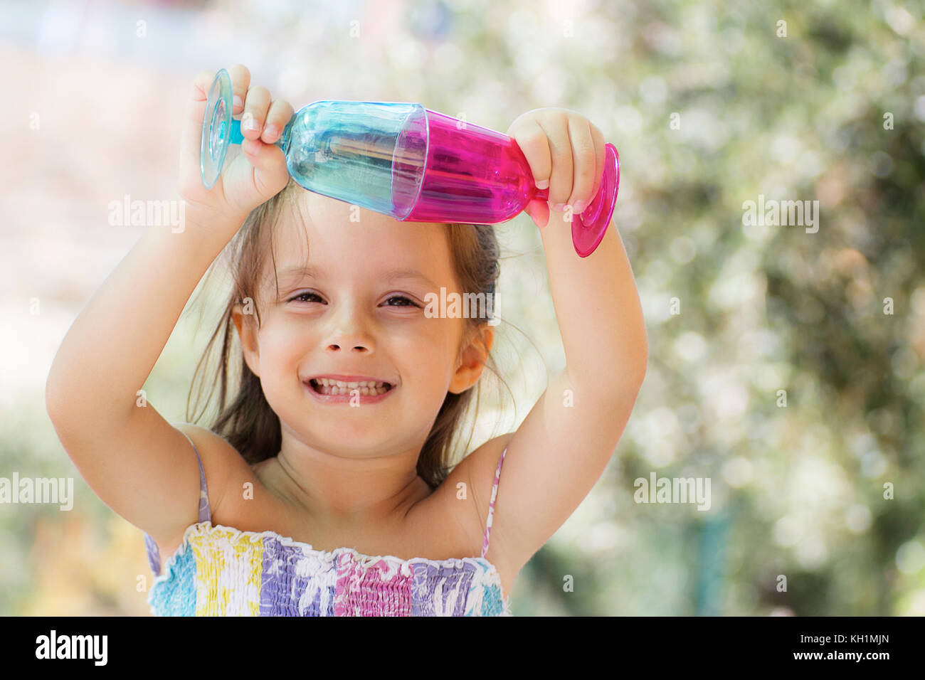 A smiling little girl play with colored glasses Stock Photo Alamy