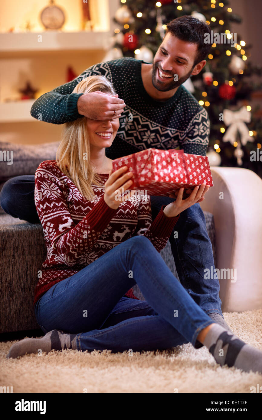 happy man surprises woman with Christmas gift Stock Photo Alamy