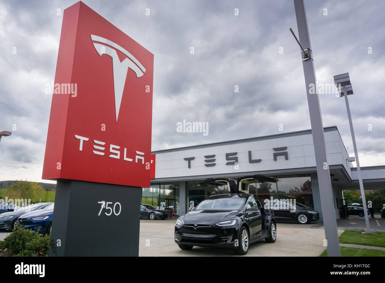 November 2, 2017 Sunnyvale/CA/USA - Tesla logo in front of a showroom located in San Francisco bay area; cloudy sky in the background Stock Photo