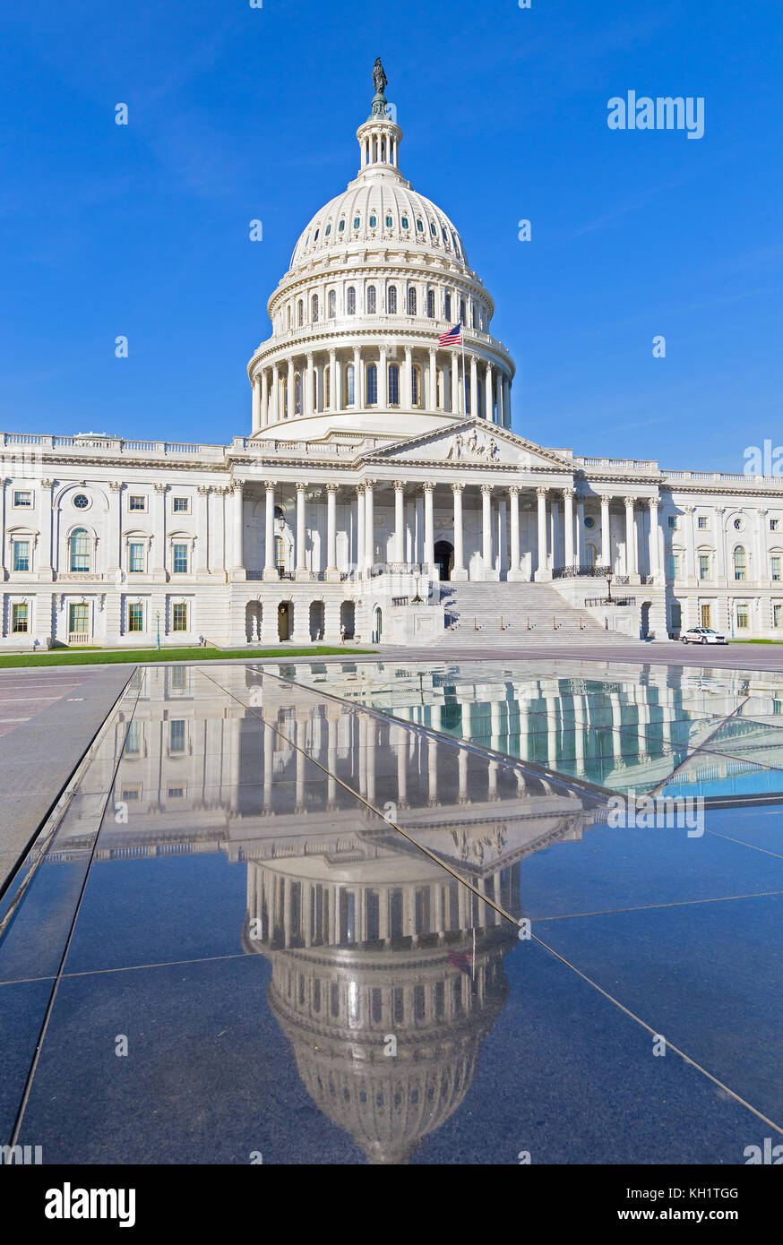 The United States Capitol monument with dome reflection in the morning. The building sits atop Capitol Hill at the eastern end of National Mall in US Stock Photo