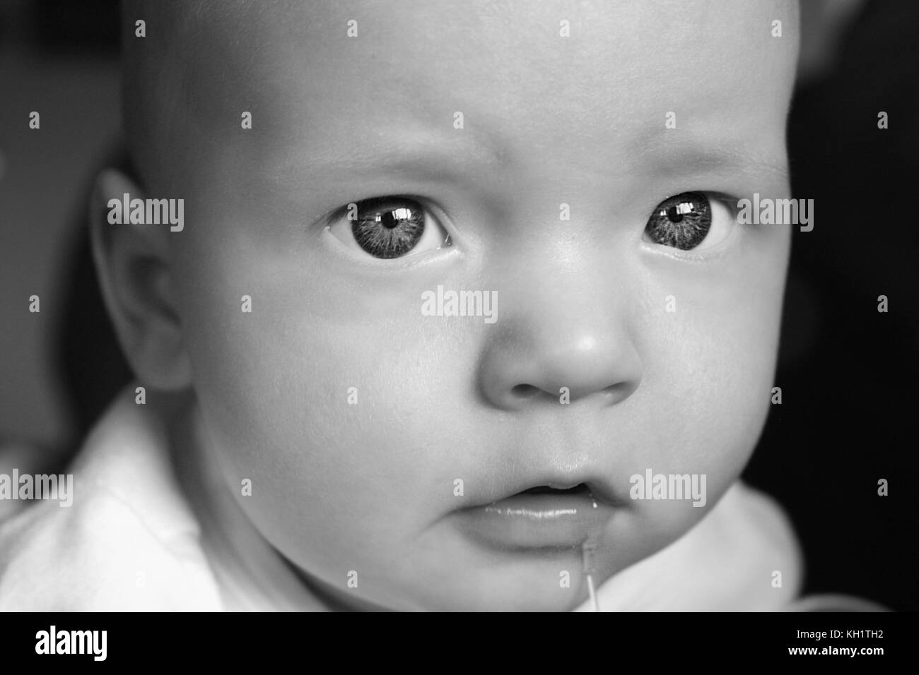 black and white baby with drool Stock Photo