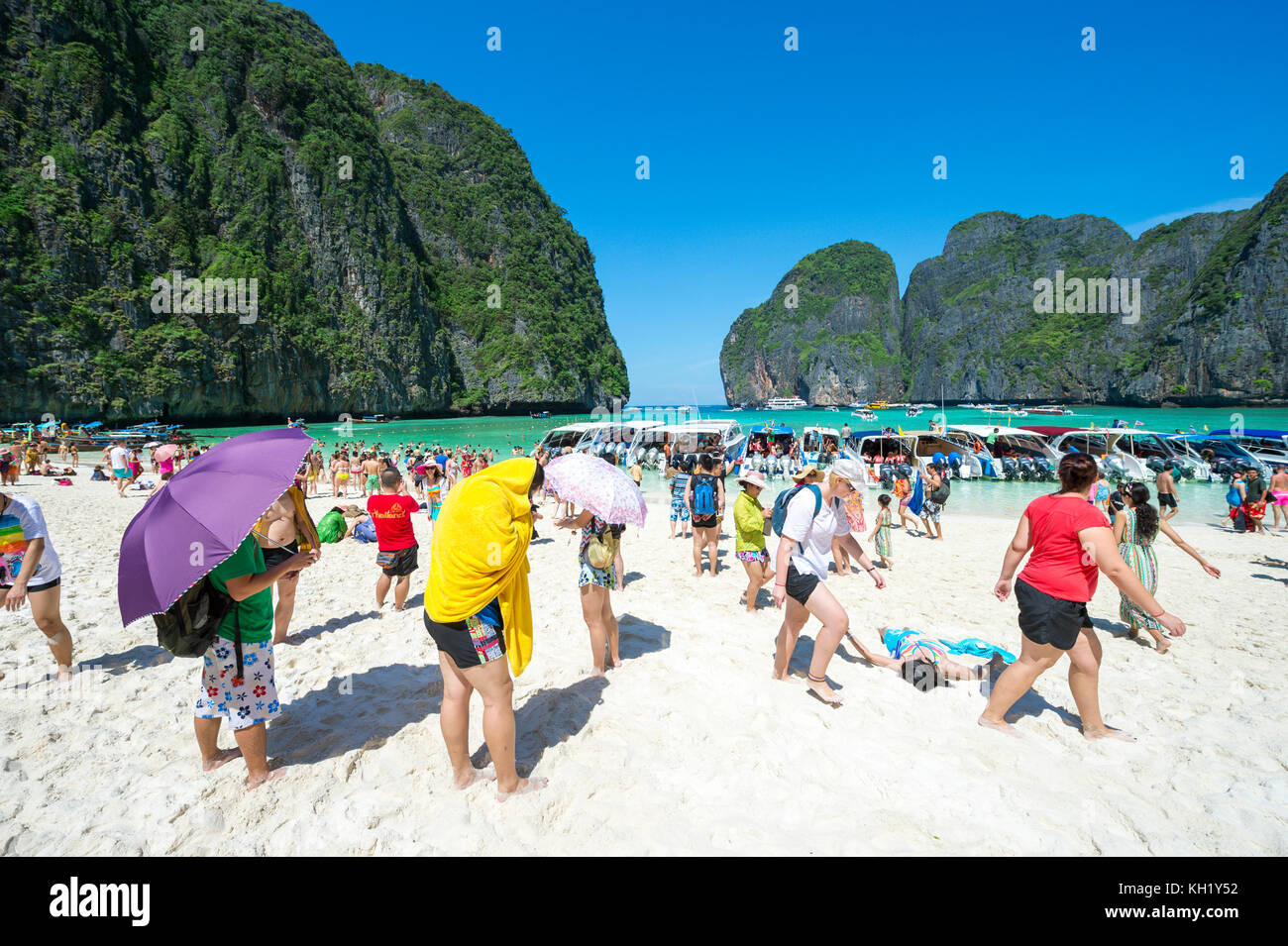 MAYA BAY, THAILAND - NOVEMBER 12, 2014: Crowds of sunbathing visitors enjoy a day trip boat ride to Maya Bay, one of the iconic beaches of Southern Th Stock Photo