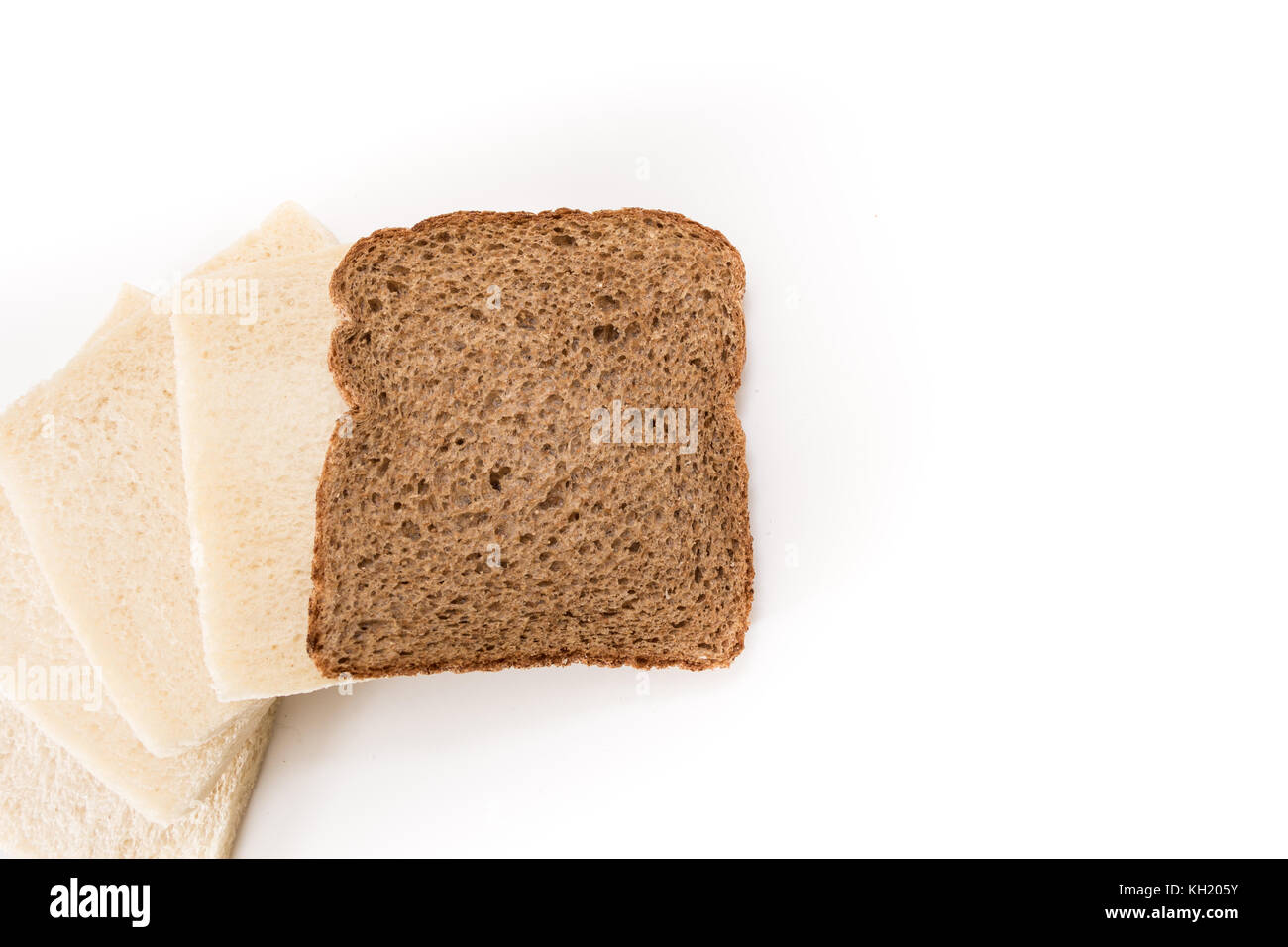 White no crust sandwich bread slices with one of them wholesome brown, on white background Stock