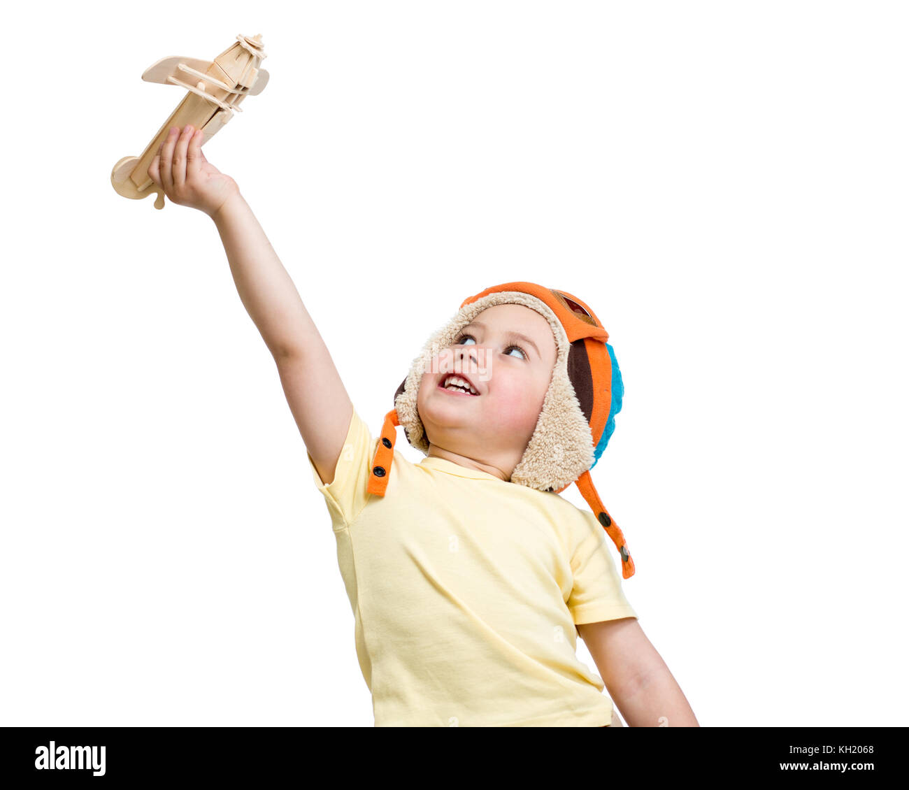 Happy kid boy in helmet pilot plays with wooden toy airplane. Isolated ...