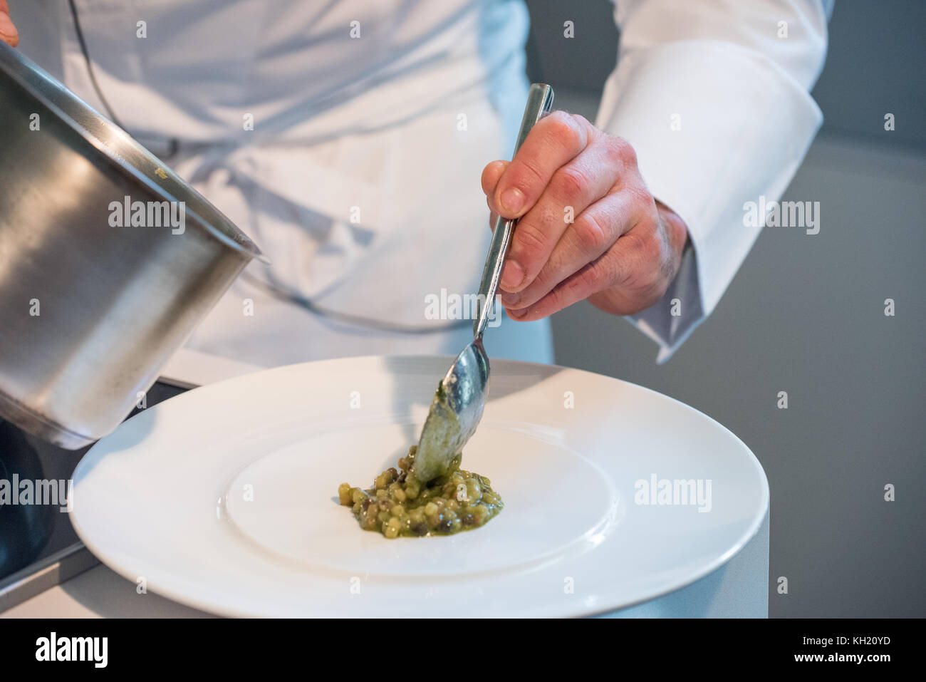 A chef spooning fregola pasta onto a dish. Stock Photo