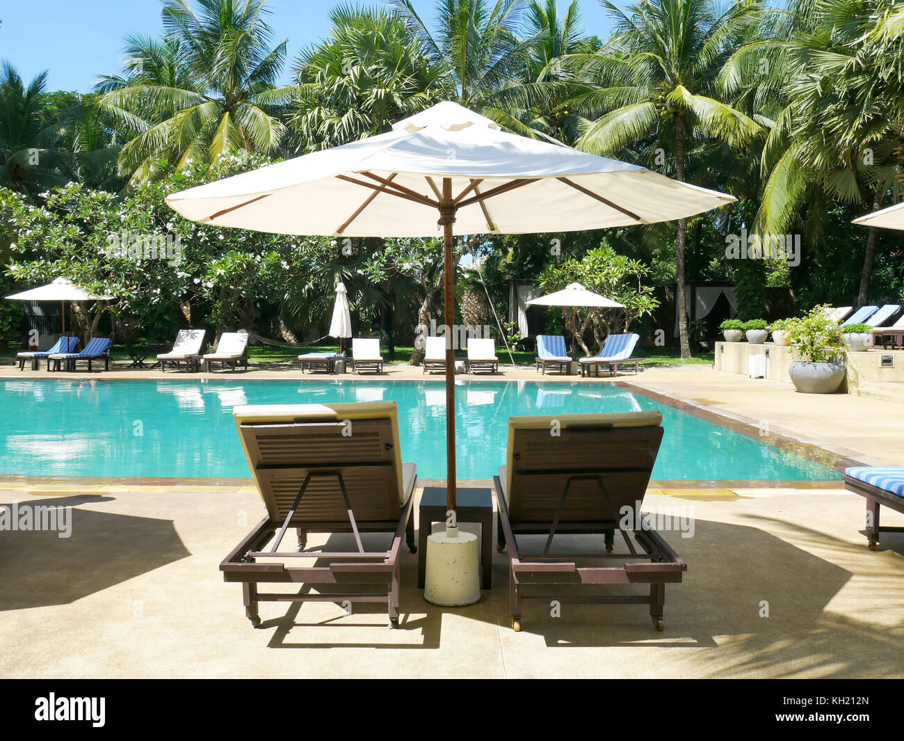 Umbrella And Chair Around Outdoor Swimming Pool In Tropical