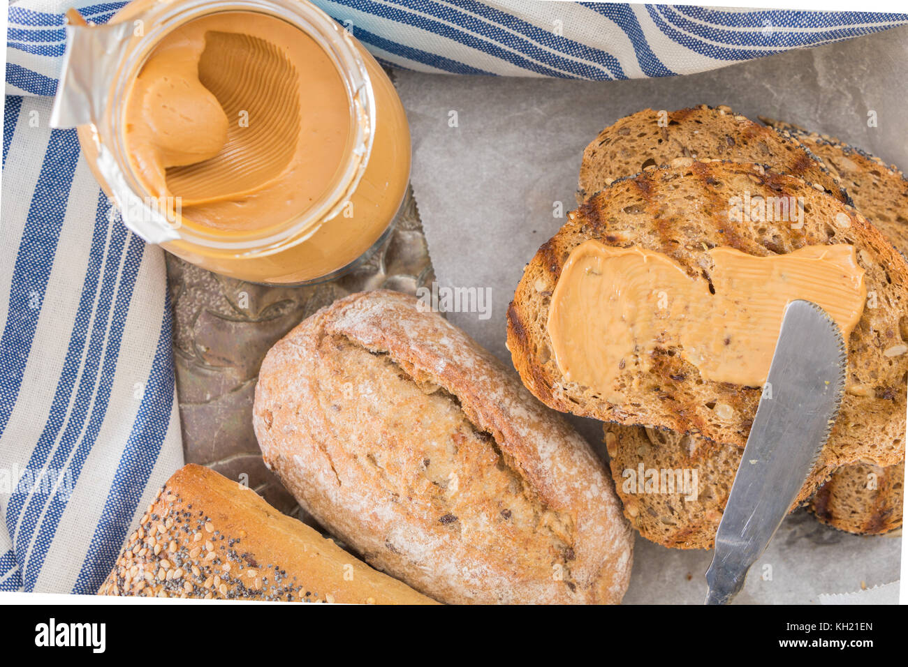 Whole wheat grilled bread slices, with opened jar of peanut butter and