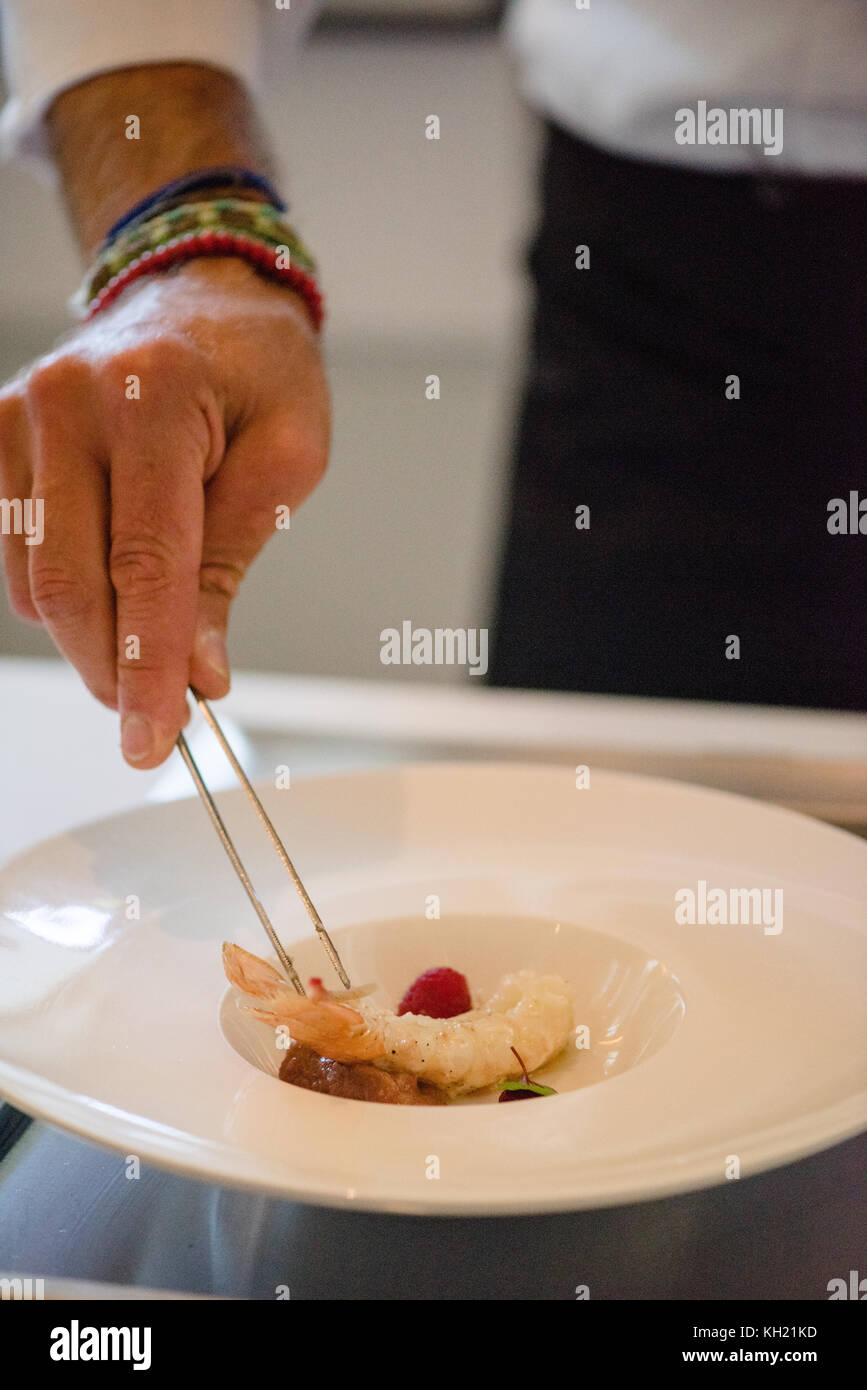 A chef delicately prepares a seafood dish Stock Photo