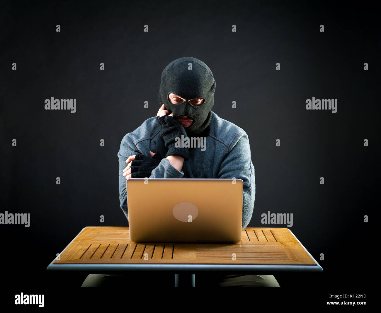 Hacker thinks how he will crack the laptop Stock Photo - Alamy