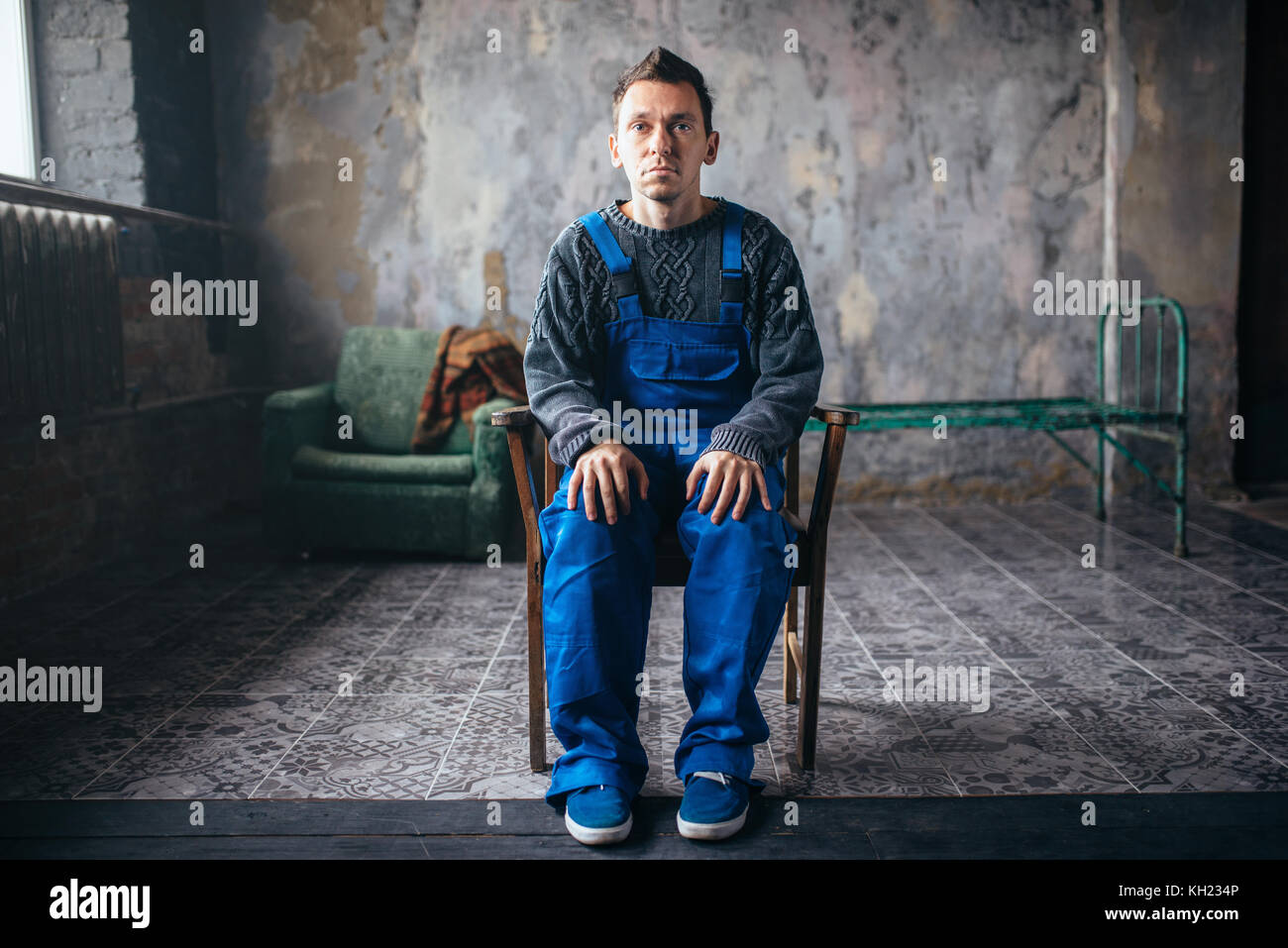 Crasy man sitting in the chair, psycho patient Stock Photo