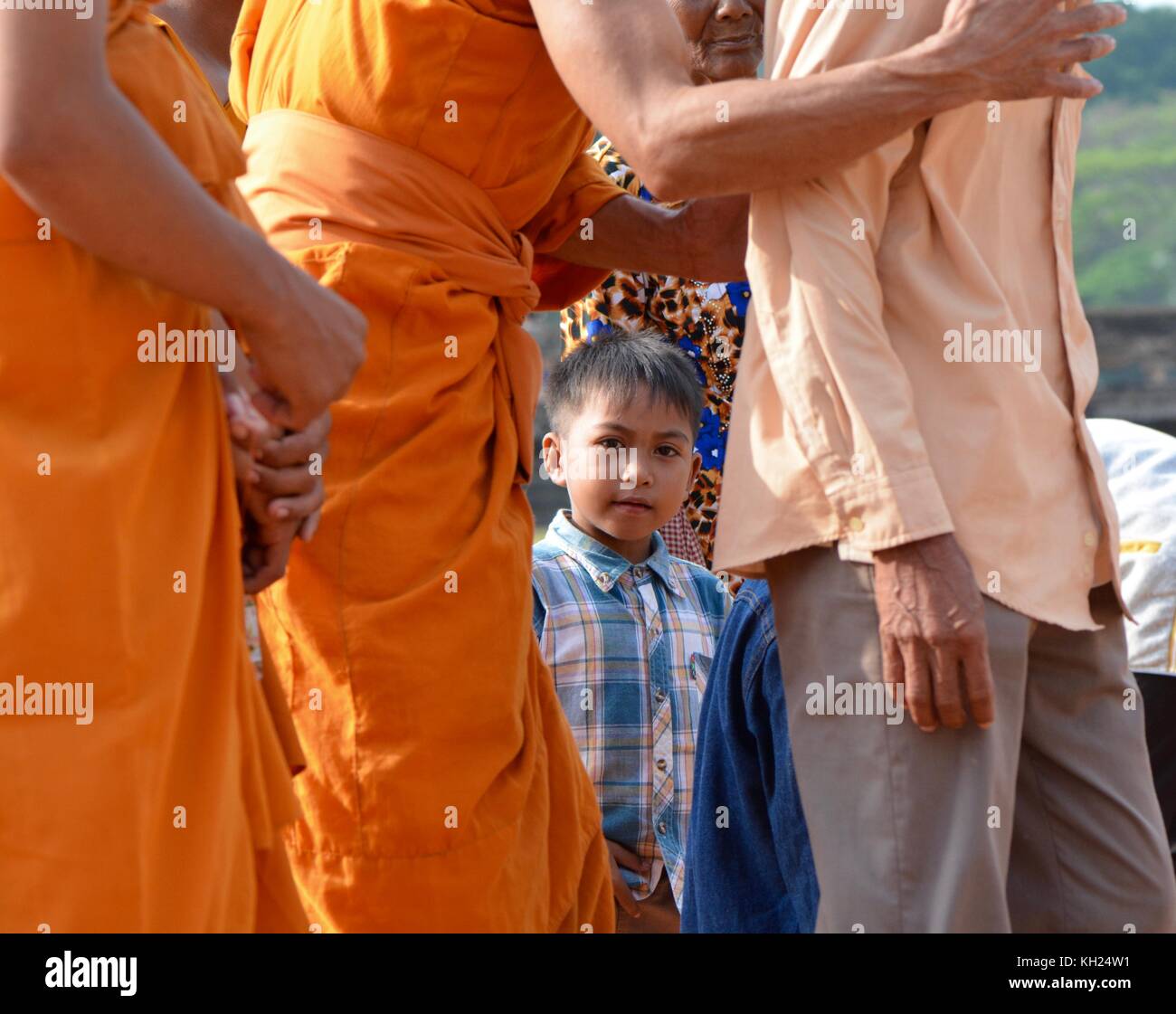 Child in the midst of monks Stock Photo