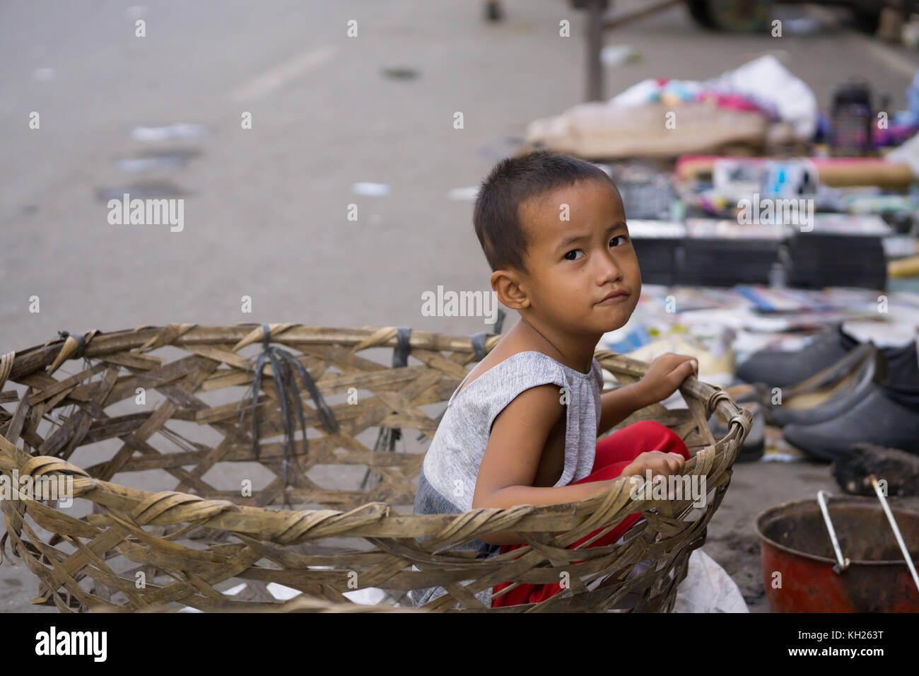 A Filipino boy sitting in a basket,downtown Cebu City,Philippines Stock Photo