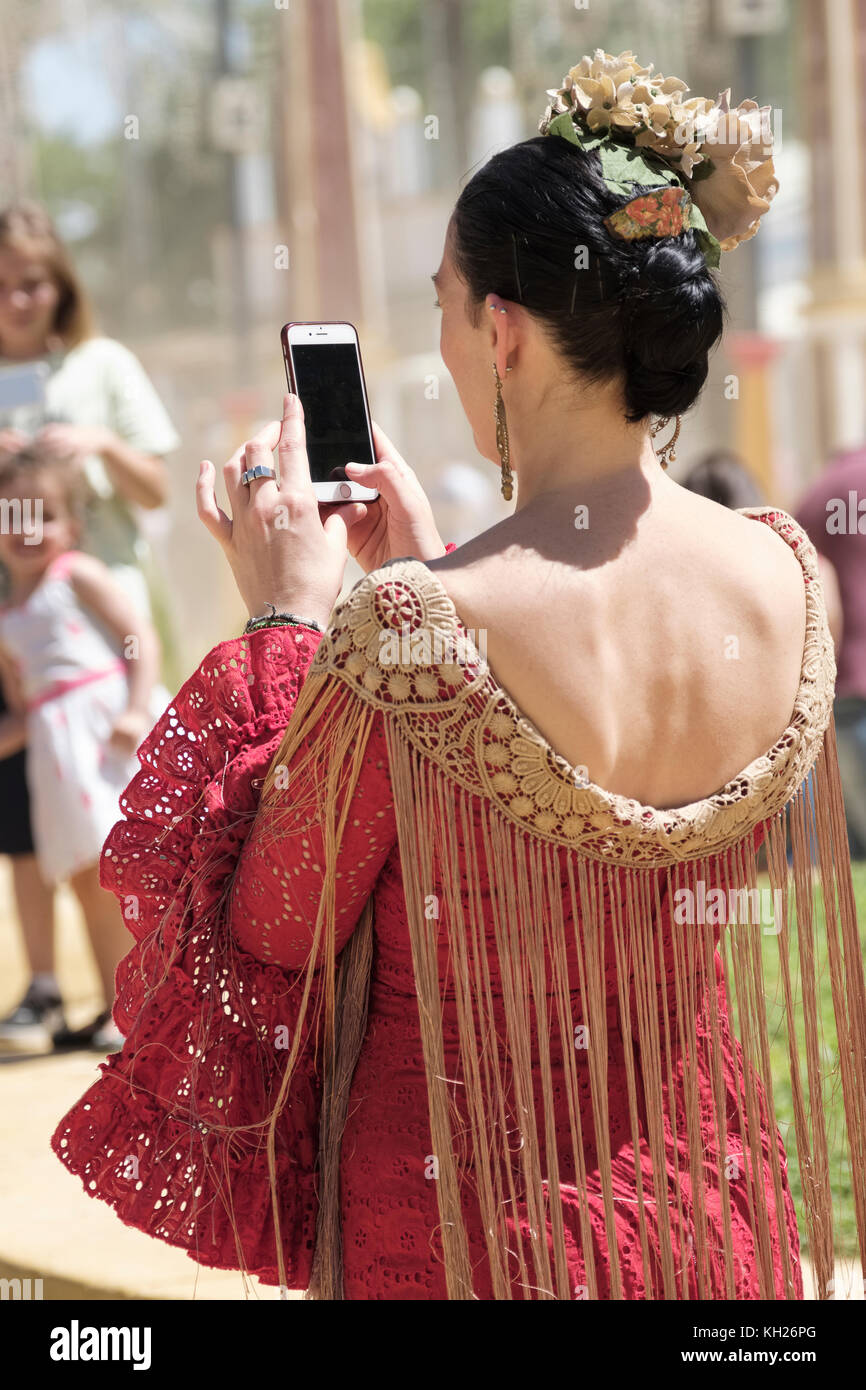 Young lady using smartphone, Jerez de la Frontera, Feria de Caballo, May Horse Fair, Cadiz, Andalucia, Spain. Stock Photo
