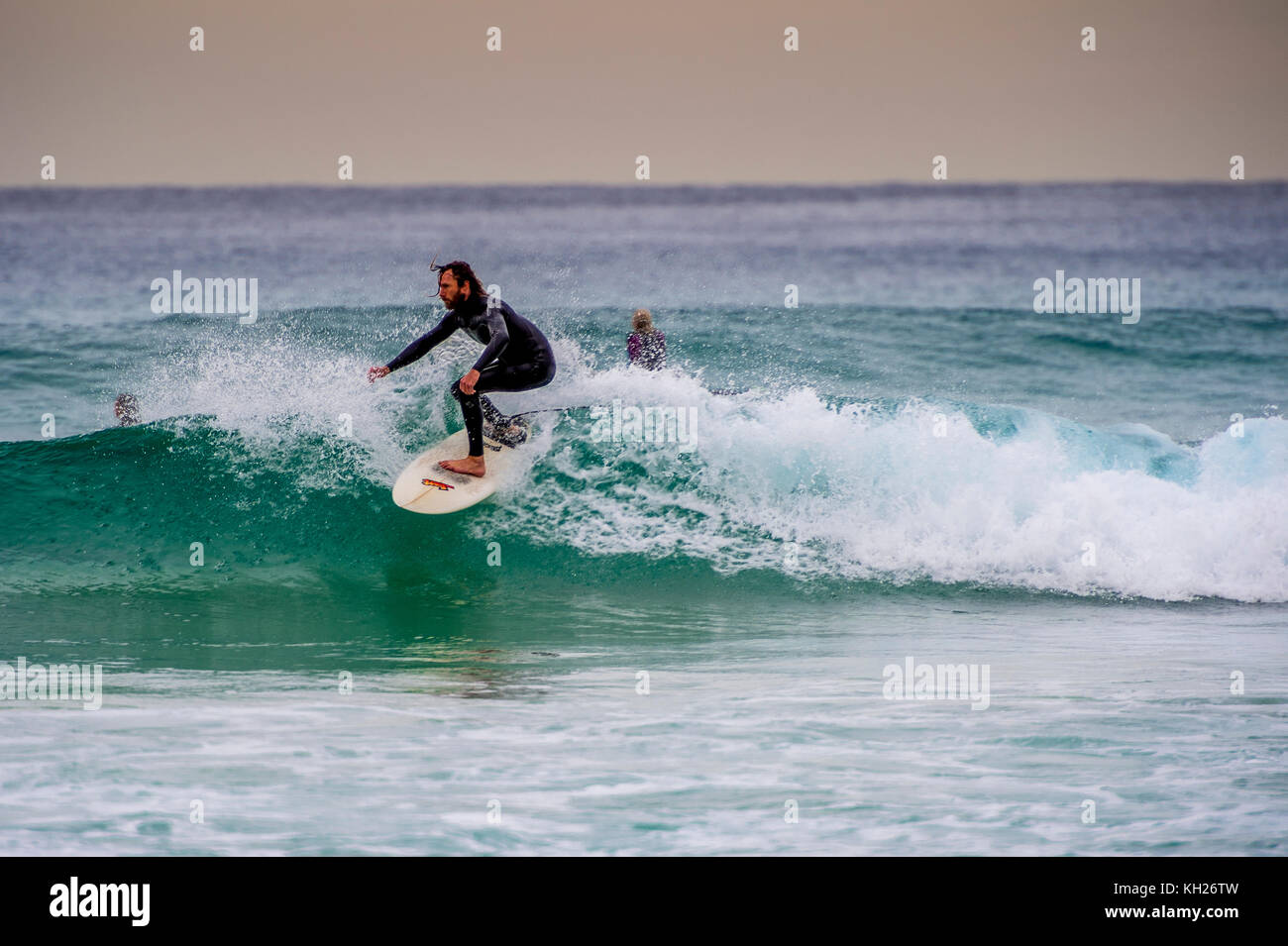 A surfer rides a wave at Sydney's iconic Bondi Beach, NSW, Australia Stock Photo
