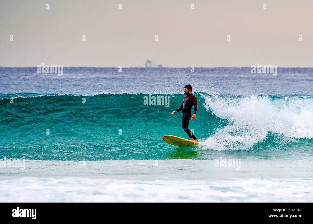 A surfer ride a wave at Sydney's iconic Bondi Beach, NSW, Australia Stock Photo