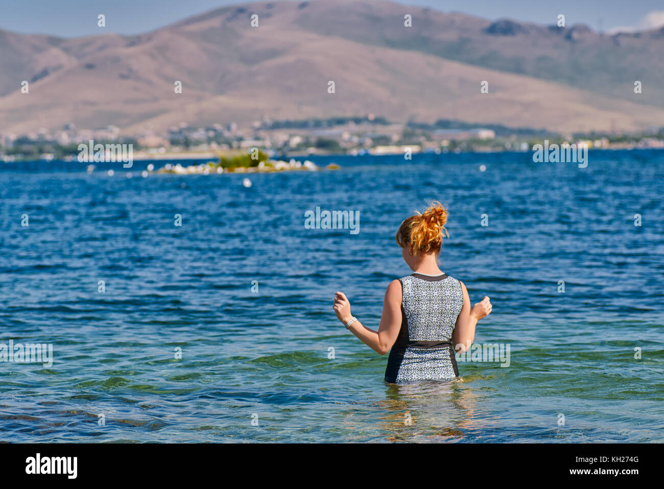 Young Woman going swimming in fresh waters of Lake Sevan of Armenia Stock Photo