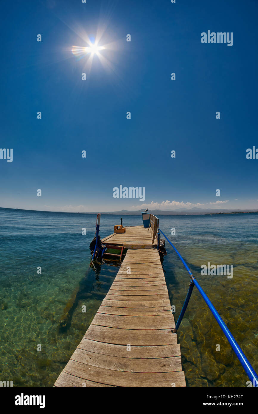 Wooden pier on Transparent waters of Mountain Lake Sevan of Armenia Stock Photo