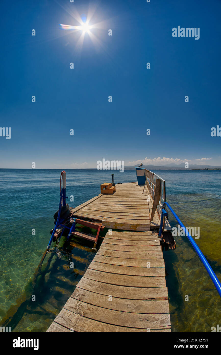Wooden pier on Transparent waters of Mountain Lake Sevan of Armenia Stock Photo