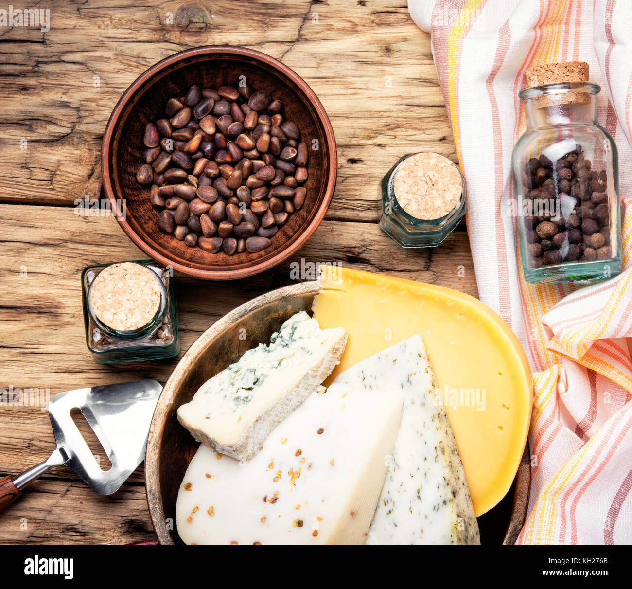 Three varieties of cheese with pine nuts on a retro wooden background Stock Photo