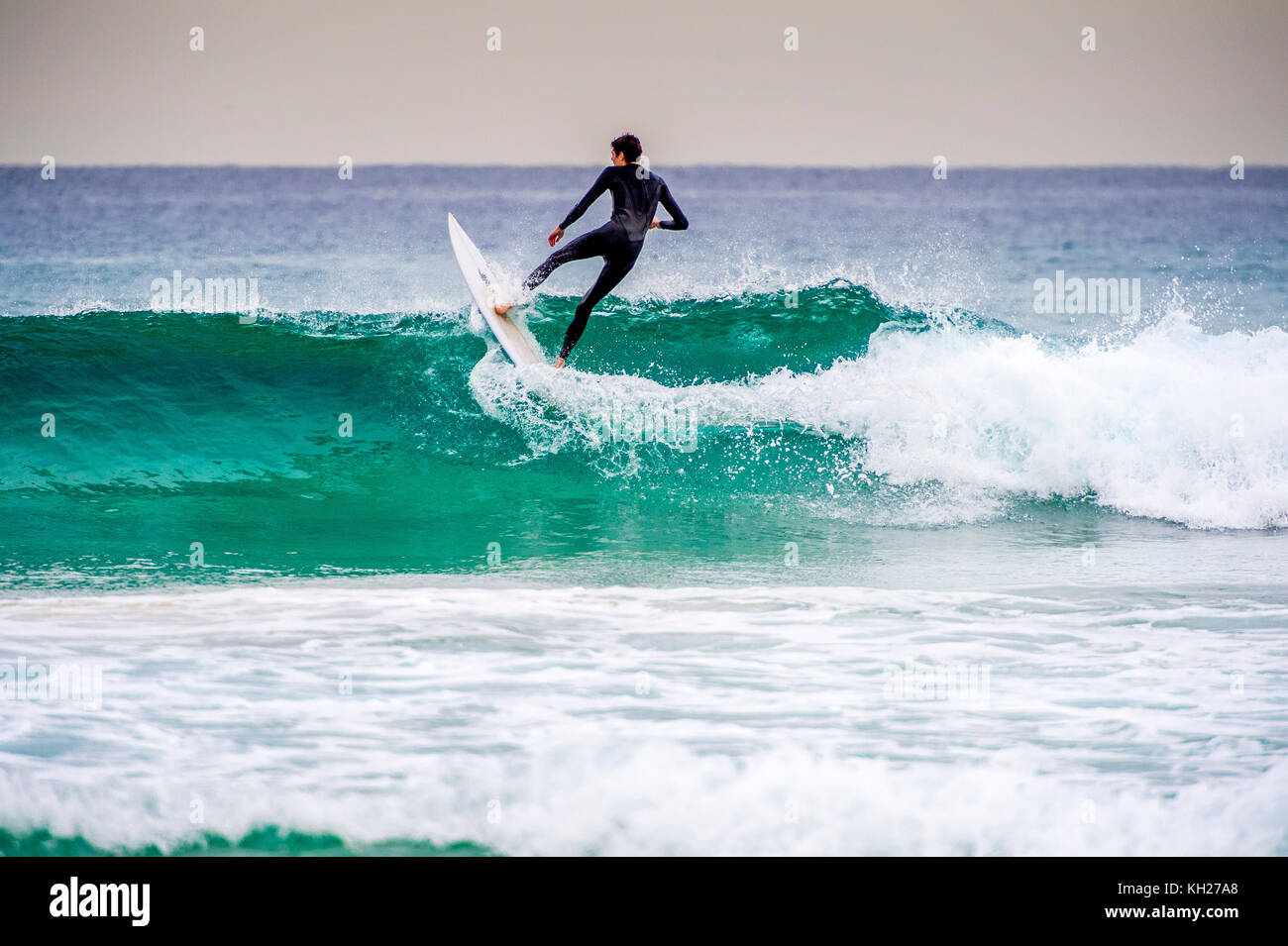 A surfer ride a wave at Sydney's iconic Bondi Beach, NSW, Australia
