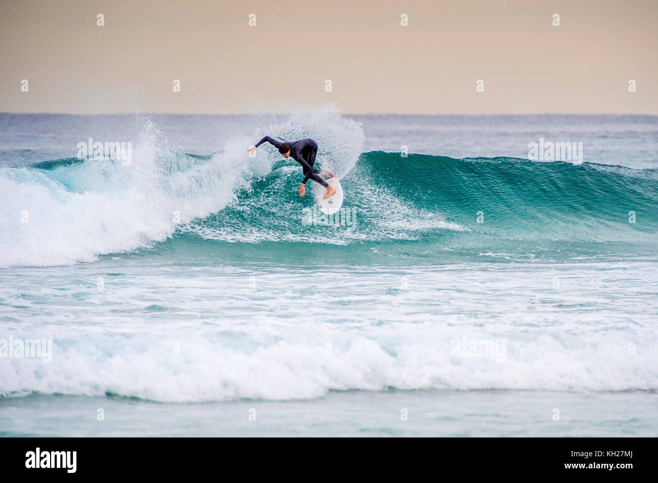 A surfer ride a wave at Sydney's iconic Bondi Beach, NSW, Australia