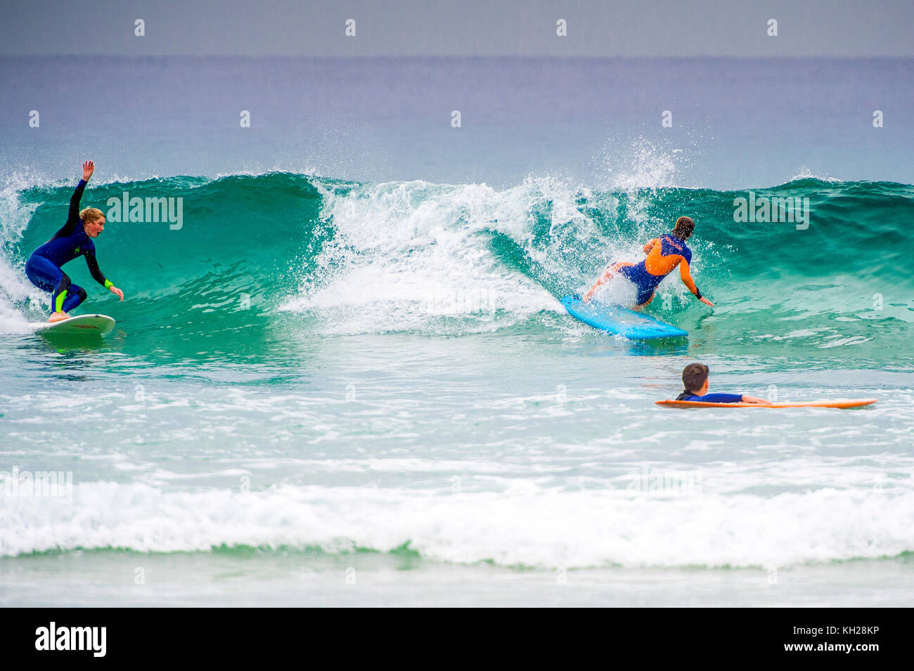 Multiple surfers ride a wave at Sydney's iconic Bondi Beach, NSW, Australia Stock Photo