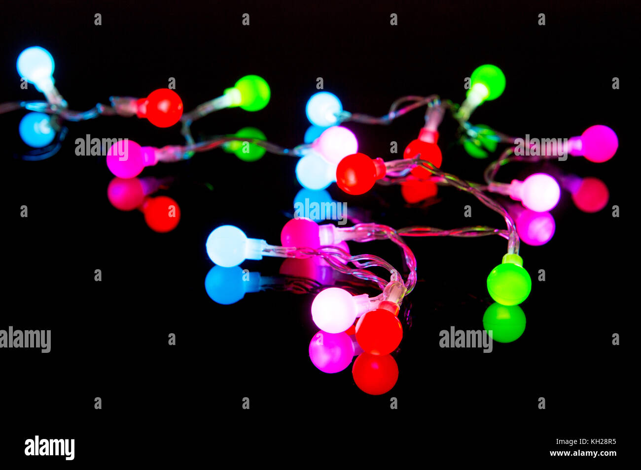 Colorful Christmas lights with reflection on back underground Stock