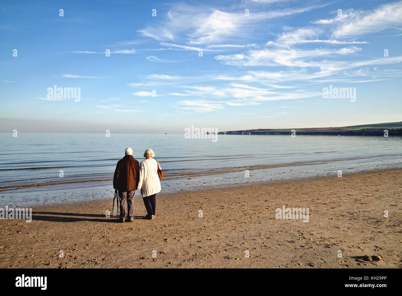 Elderly couple looking out to sea at Studland beach on an autumn day Dorset England UK Stock Photo
